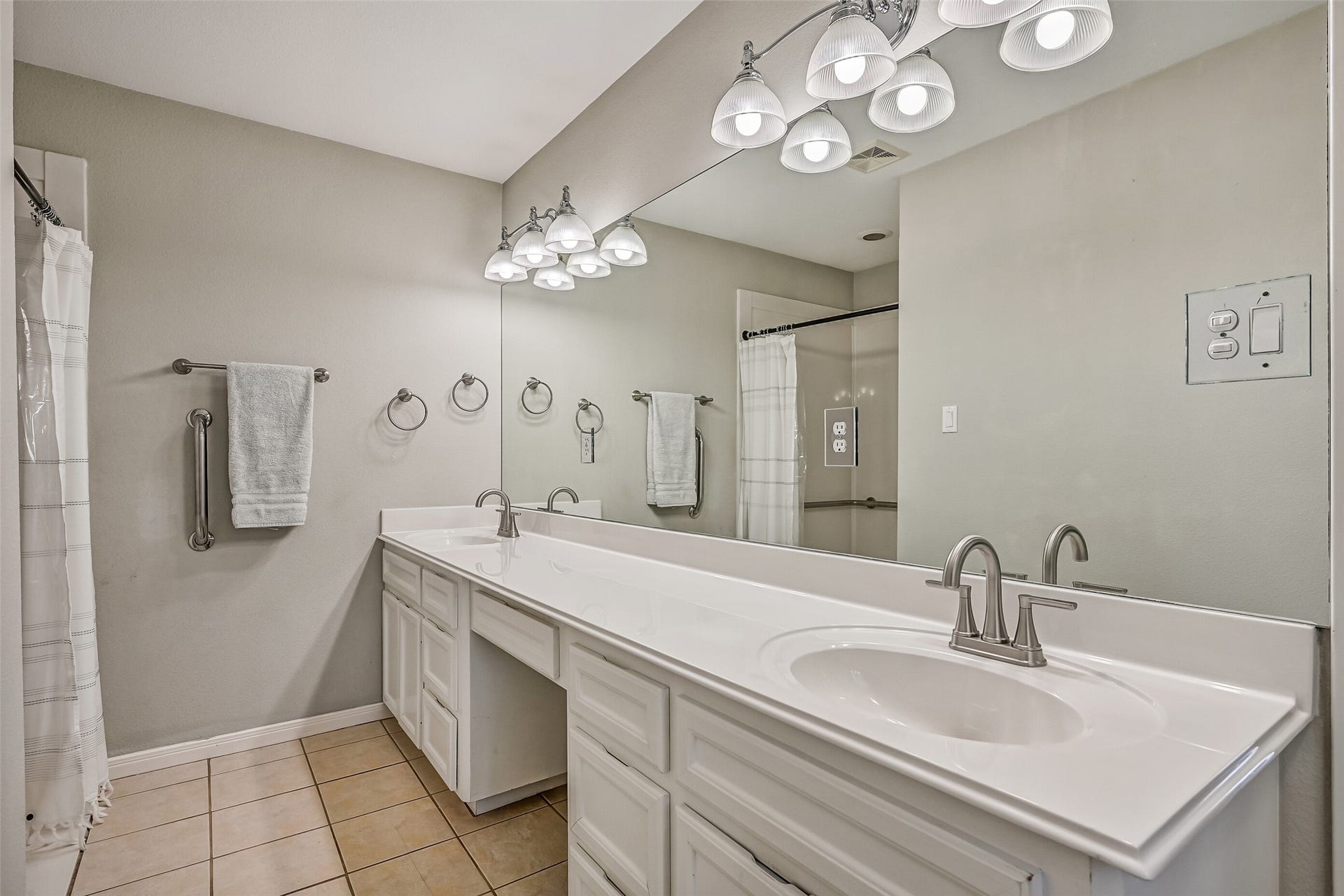 304 Chester Drive, Friendswood, TX 77546 Primary Bathroom Second Residence:
Spacious en suite bath designed with accessibility in mind, featuring an extended dual-sink vanity with generous counter space and storage. An oversized walk-in shower includes thoughtfully placed grab bars and a wide entry for ease of use. Neutral finishes, bright lighting, and tile flooring complete this comfortable and functional retreat.