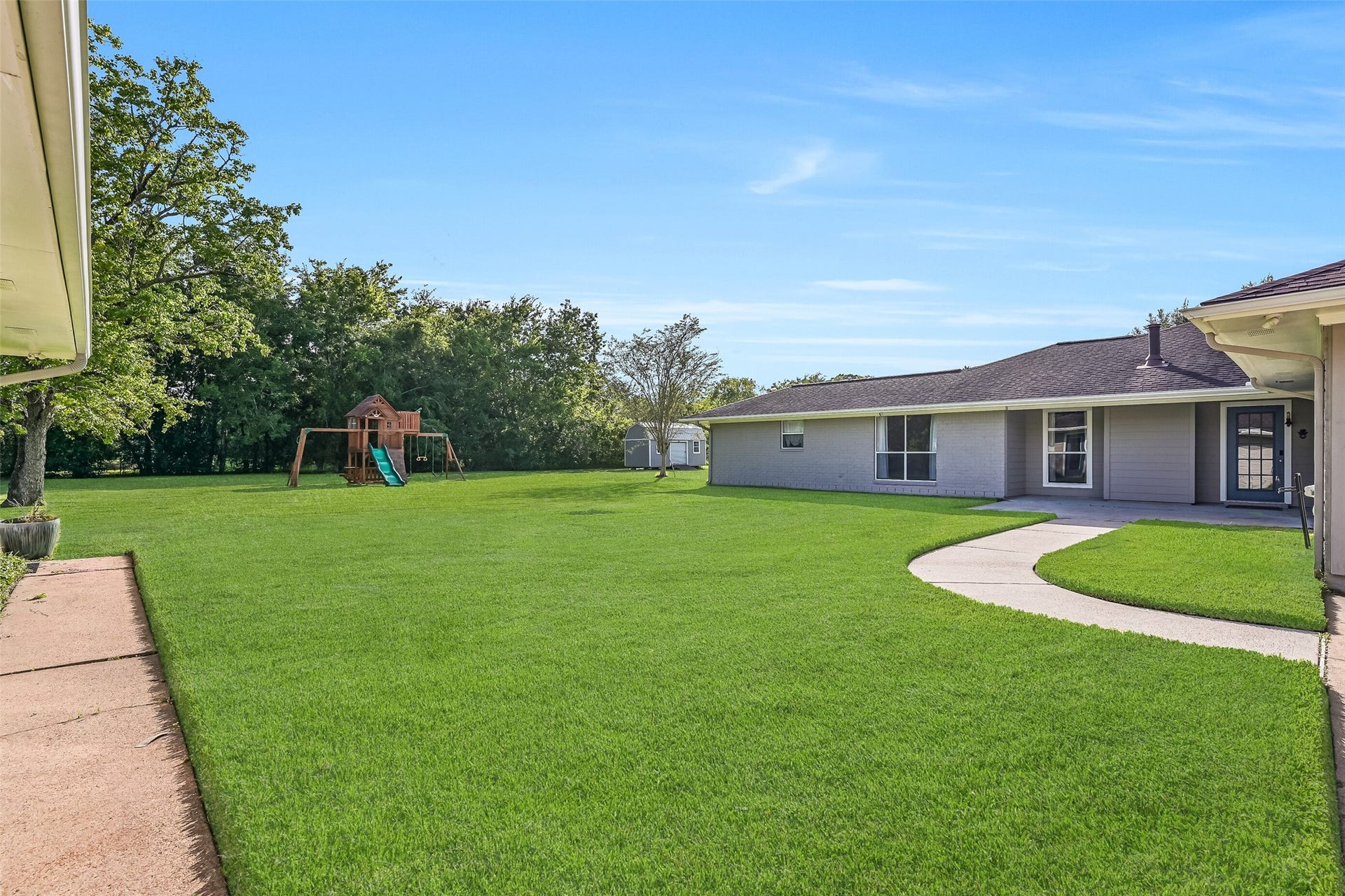 304 Chester Drive, Friendswood, TX 77546 Stepping out the back door of the first residence, a concrete walkway provides access to the converted garage space, while a gently curved path leads to an additional concrete patio situated between the two residences.