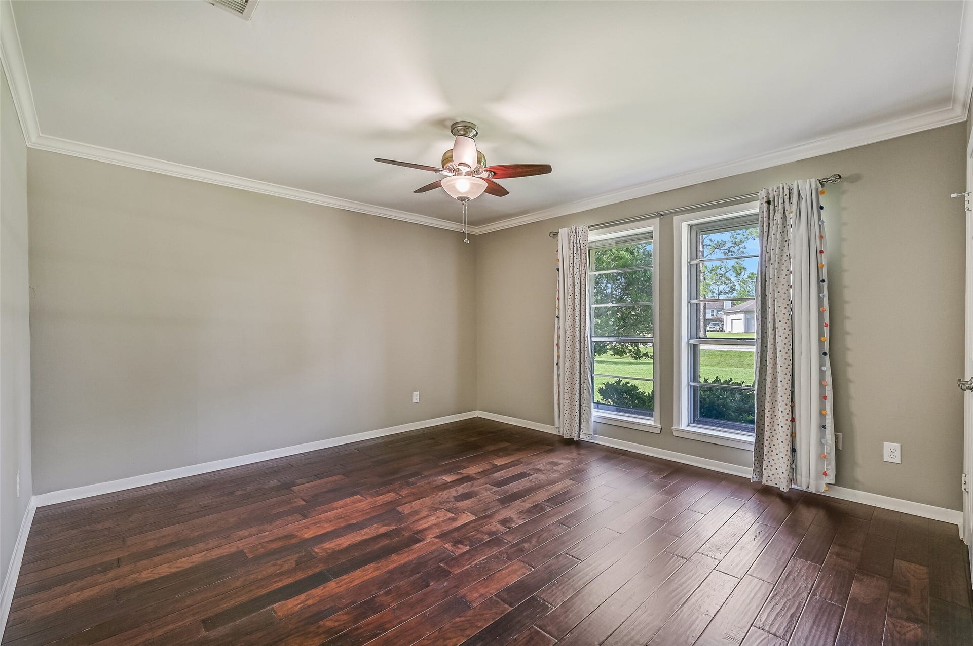 304 Chester Drive, Friendswood, TX 77546 Bedroom 1 First Residence:
The first of two spacious secondary bedrooms in the first residence features wood flooring, neutral paint, a lighted ceiling fan, two double-door closets, and two front-facing windows with draperies.