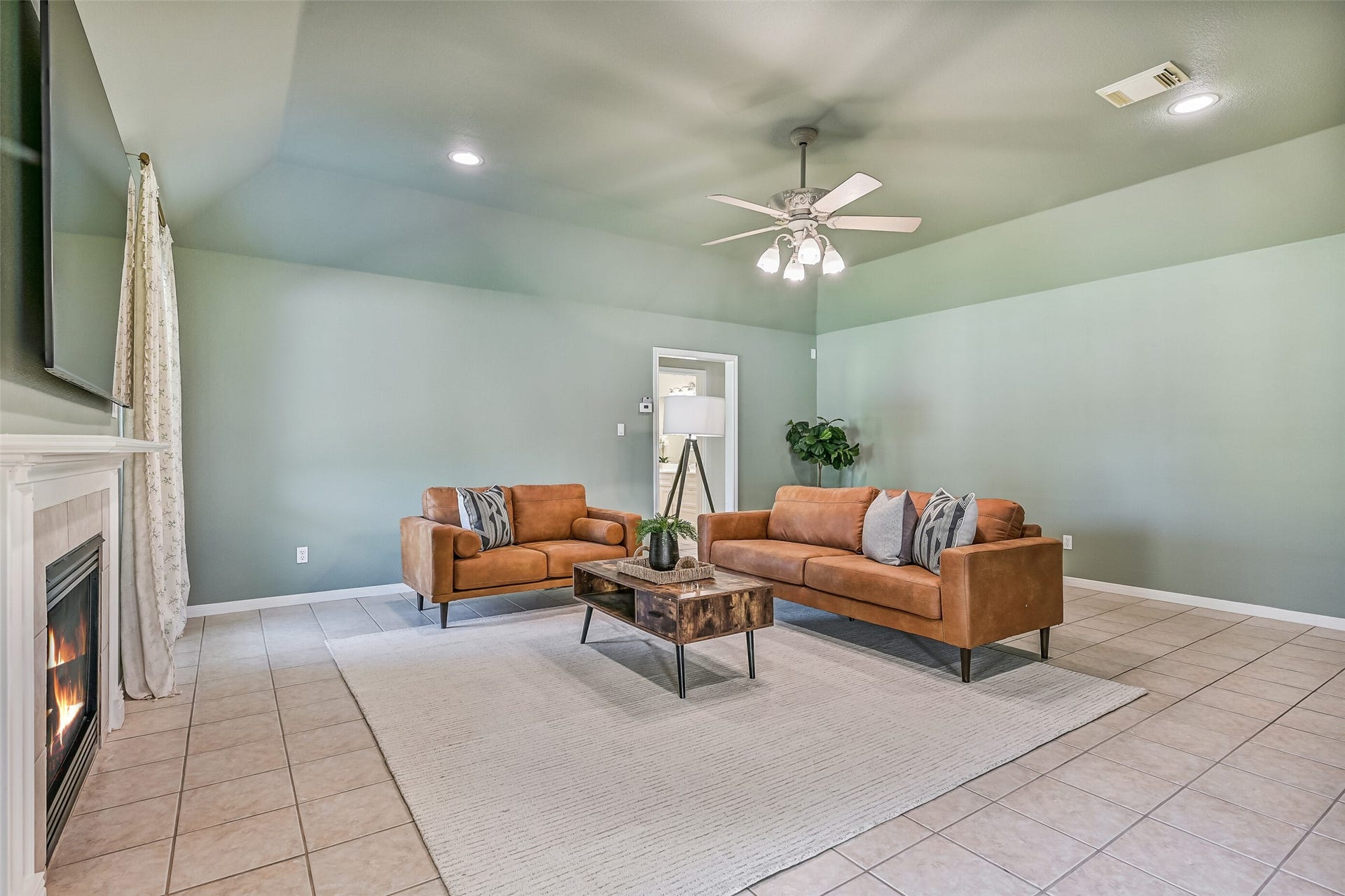 304 Chester Drive, Friendswood, TX 77546 Main Living Area Second Residence:
Moving into the main living area of the second residence, note the gambrel ceiling with recessed lighting and a lighted ceiling fan, cozy electric fireplace, and handicap friendly tile flooring & wide doorways. The open, step-free layout allows for easy mobility and flexible furniture placement.