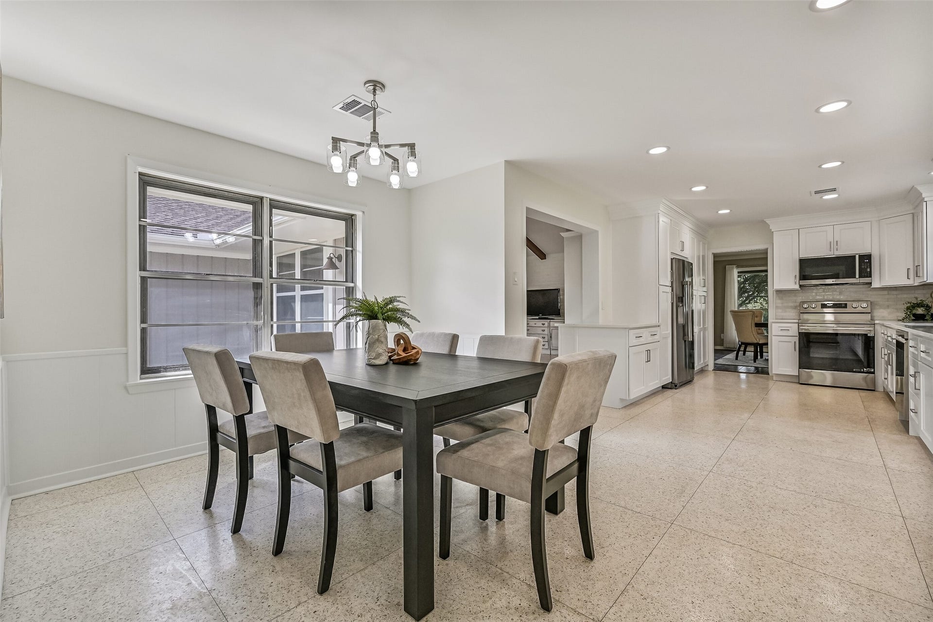304 Chester Drive, Friendswood, TX 77546 Breakfast Room First Residence:
Terrazzo tile flows throughout the spacious breakfast room accented fresh paint and a modern chandelier, with large windows that fill the space with natural light and open sightlines into the kitchen and family room.
