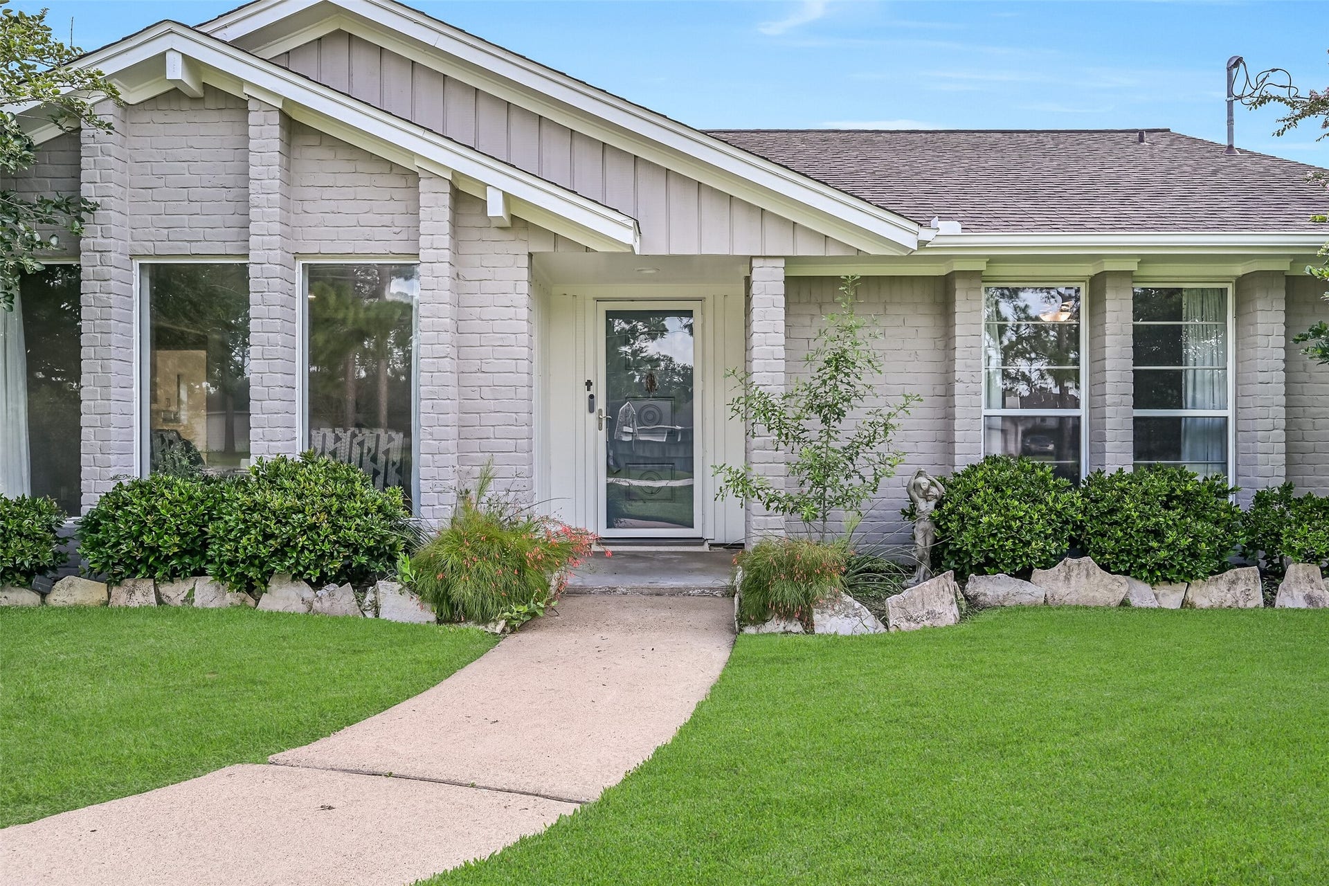 304 Chester Drive, Friendswood, TX 77546 Front Porch First Residence:
A concrete path winds from the driveway of the first home to this covered front porch with brick columns, charming gabled rooflines, and a recessed entry, complemented by manicured landscaping.
