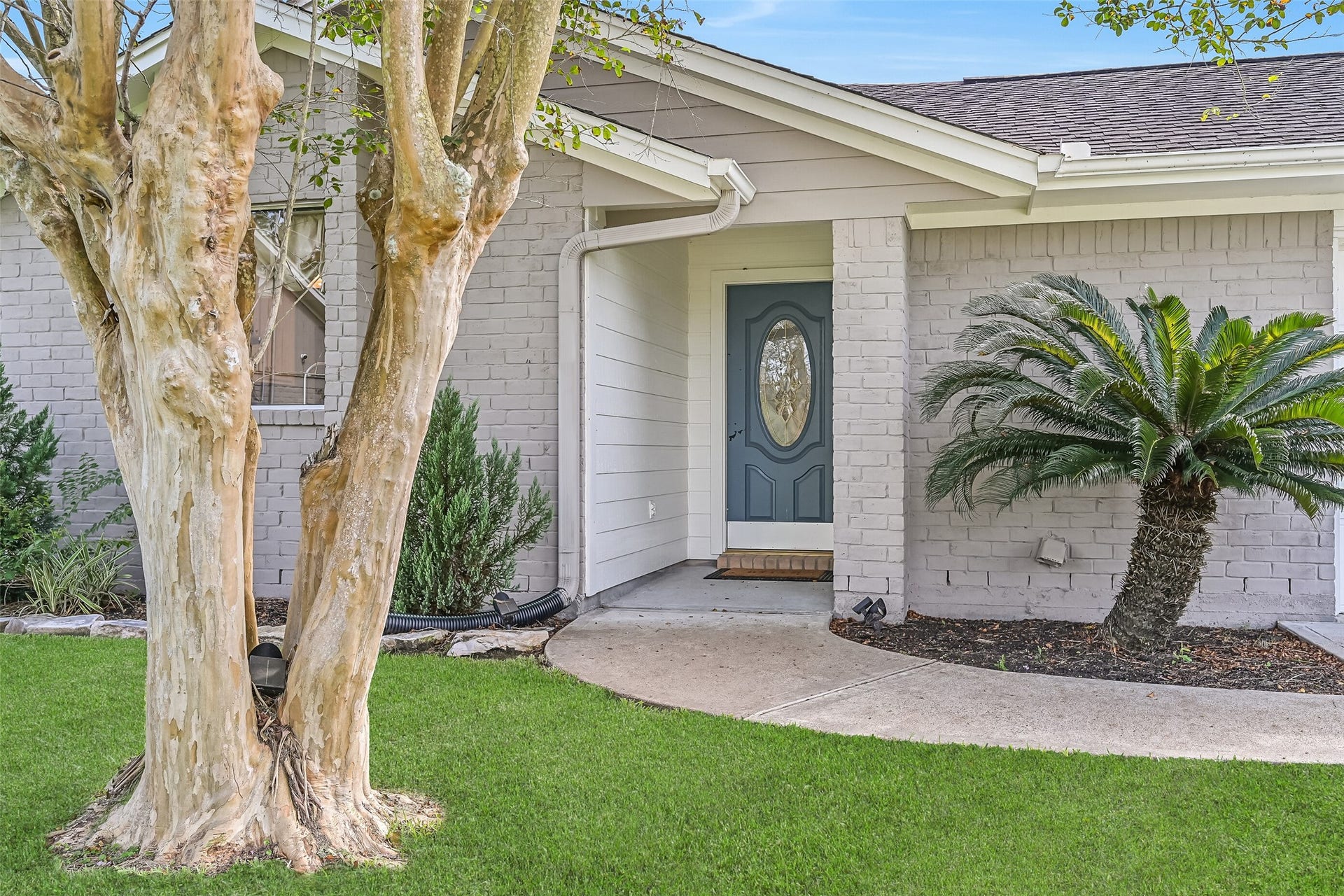 304 Chester Drive, Friendswood, TX 77546 Front Porch Second Residence:
A concrete path winds from the driveway of the second home to this covered front porch with a brick column, charming gabled rooflines, and a recessed entry, complemented by manicured landscaping.