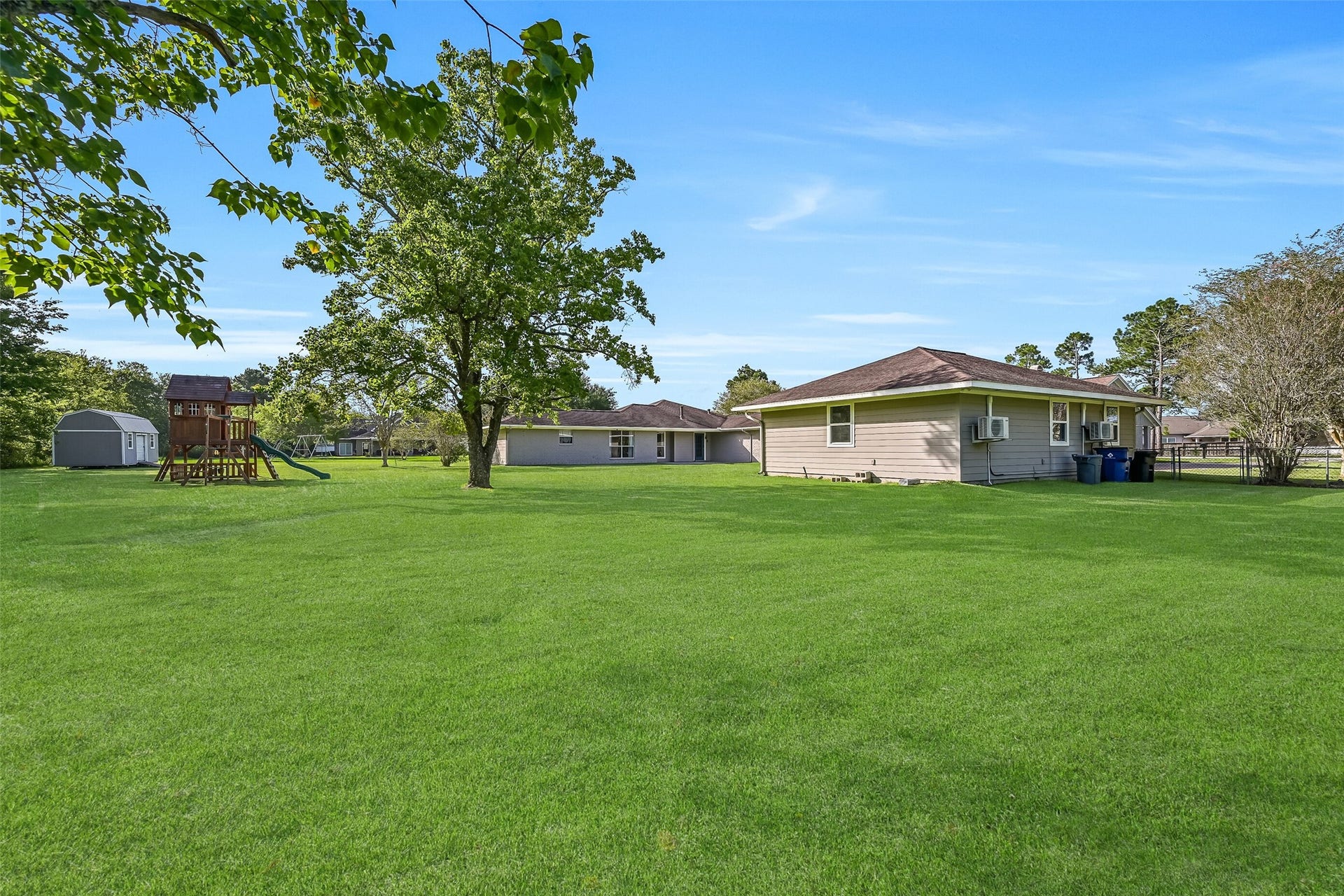 304 Chester Drive, Friendswood, TX 77546 Backyard Overview:
An expansive, park-like backyard showcases wide open green space dotted with mature trees & an included playset and storage shed. This property offers privacy, flexibility, and 1.3 acres of room to roam, without the limitations of a HOA! Dream Big!