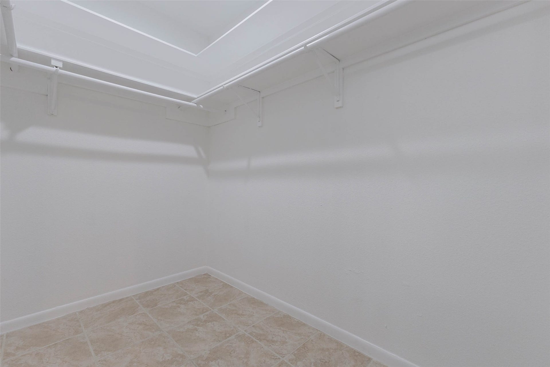 2800 Jeanetta Street, #2207, Houston, TX 77063 Spacious walk-in closet with ample hanging space and clean tiled flooring, perfect for organized storage.