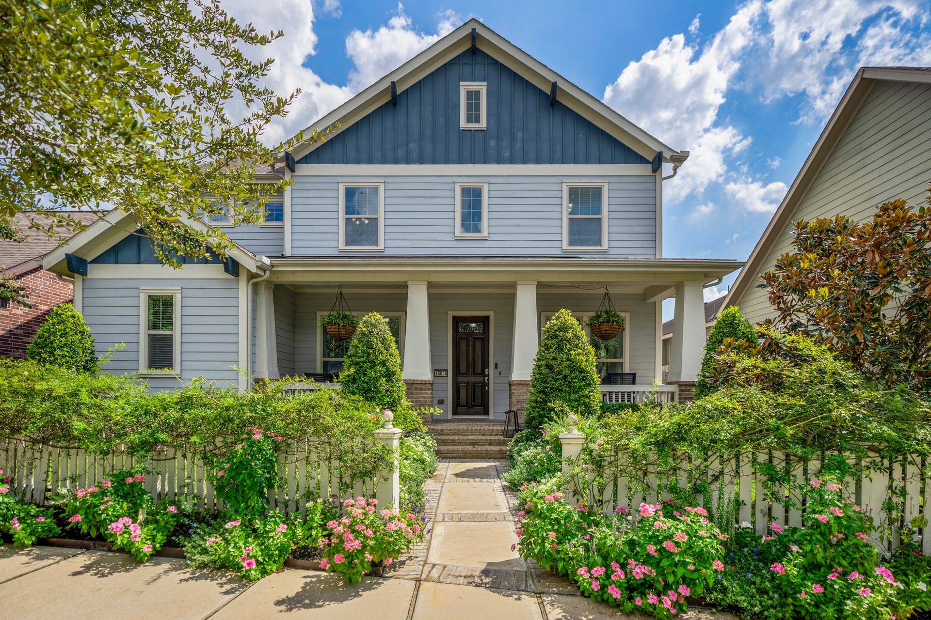 16618 Seminole Ridge Drive, Cypress, TX 77433 Charming two-story home with a welcoming front porch, lush landscaping, and a classic blue exterior accented by white trim.