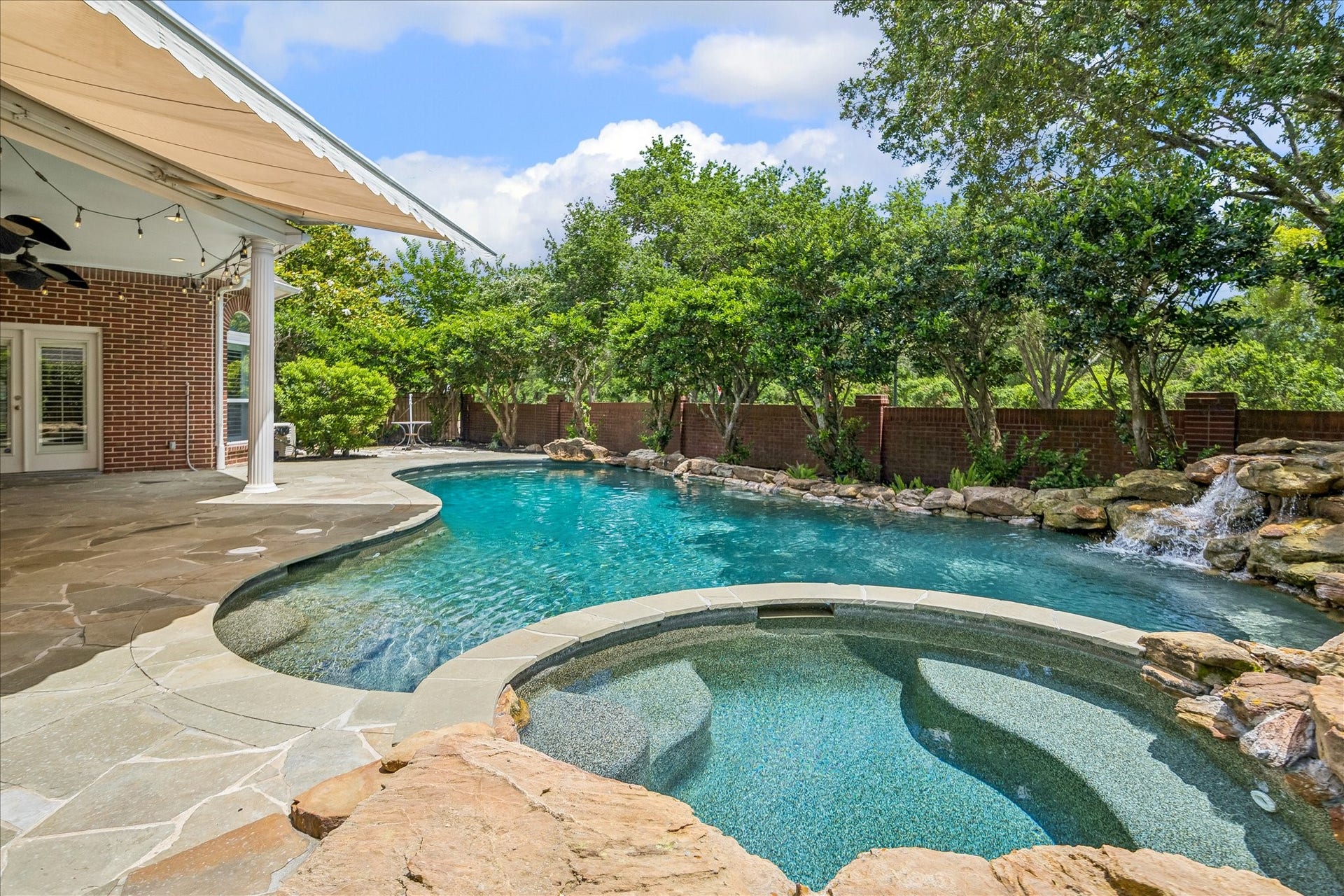 Backyard oasis! Featuring a sparkling pool and spa, this outdoor retreat is designed for both relaxation and entertaining. A covered patio provides comfortably shaded seating, while convenient access from the primary suite enhances the seamless indoor-outdoor living experience, creating a private and inviting resort-style setting.