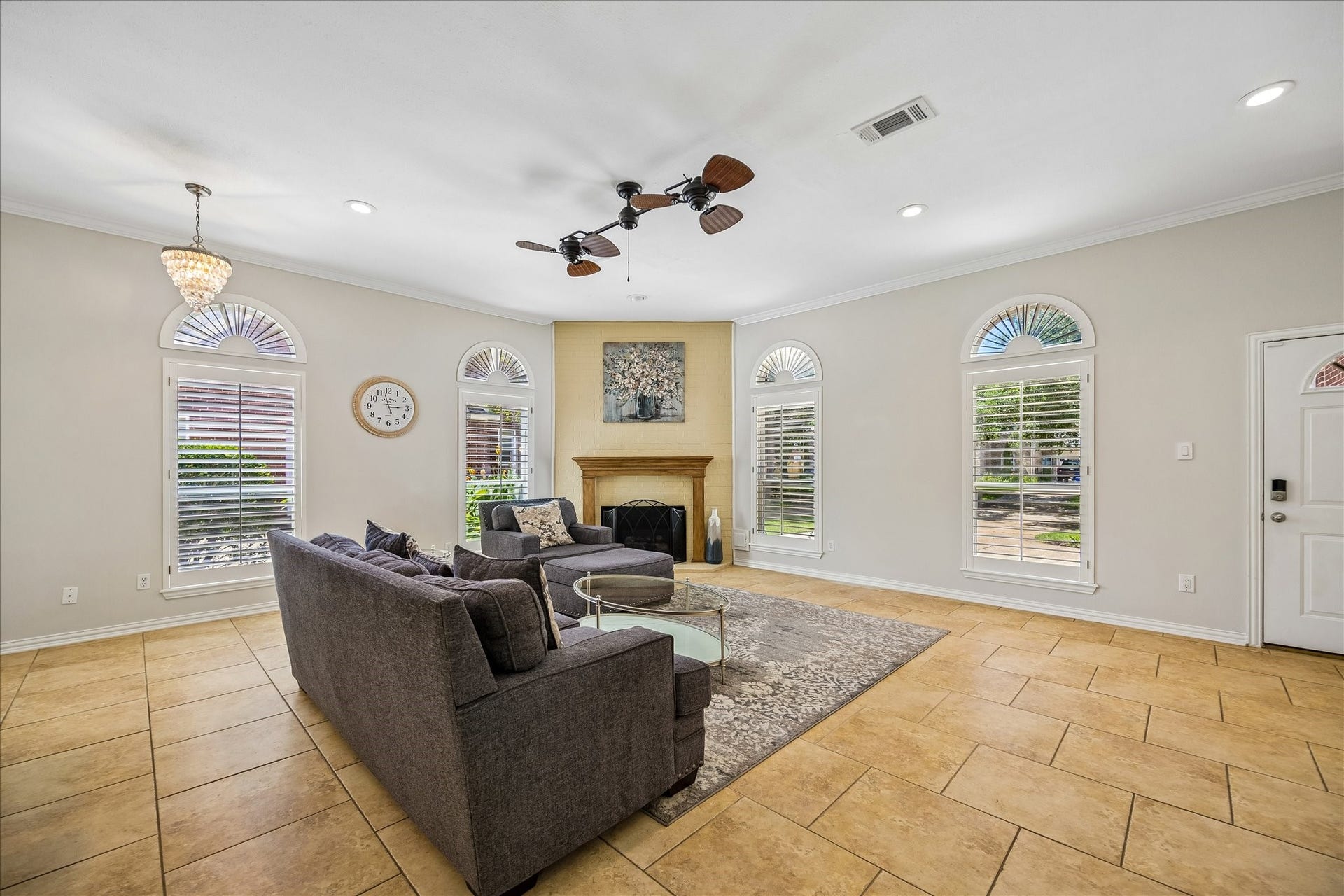 The den features a modern ceiling fan and abundant natural light, creating a warm and inviting space for relaxation, family gatherings, and entertaining guests.