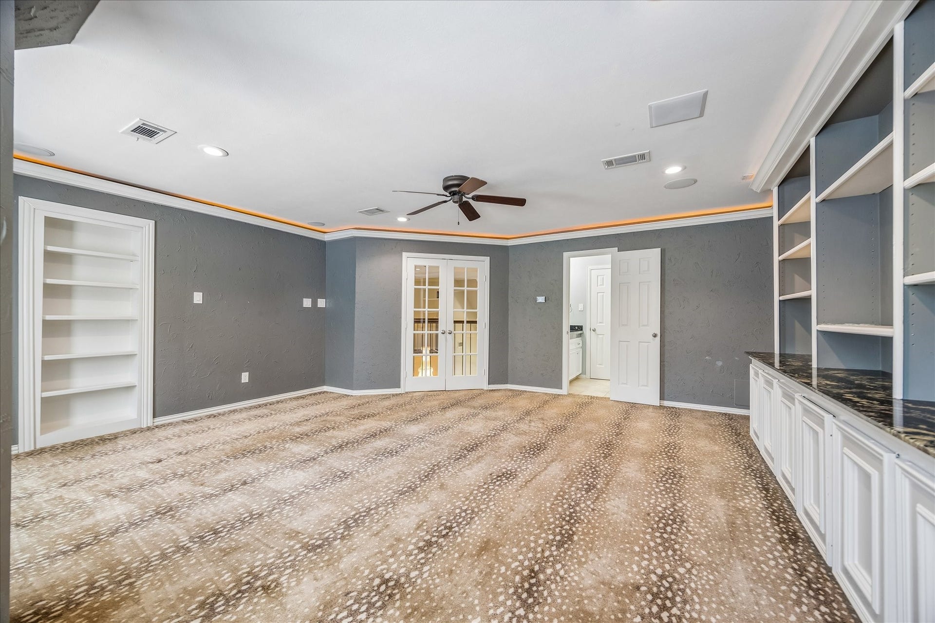 Textured walls and a patterned carpet add a stylish, designer-inspired touch, creating a comfortable yet elevated retreat for entertaining and relaxation.