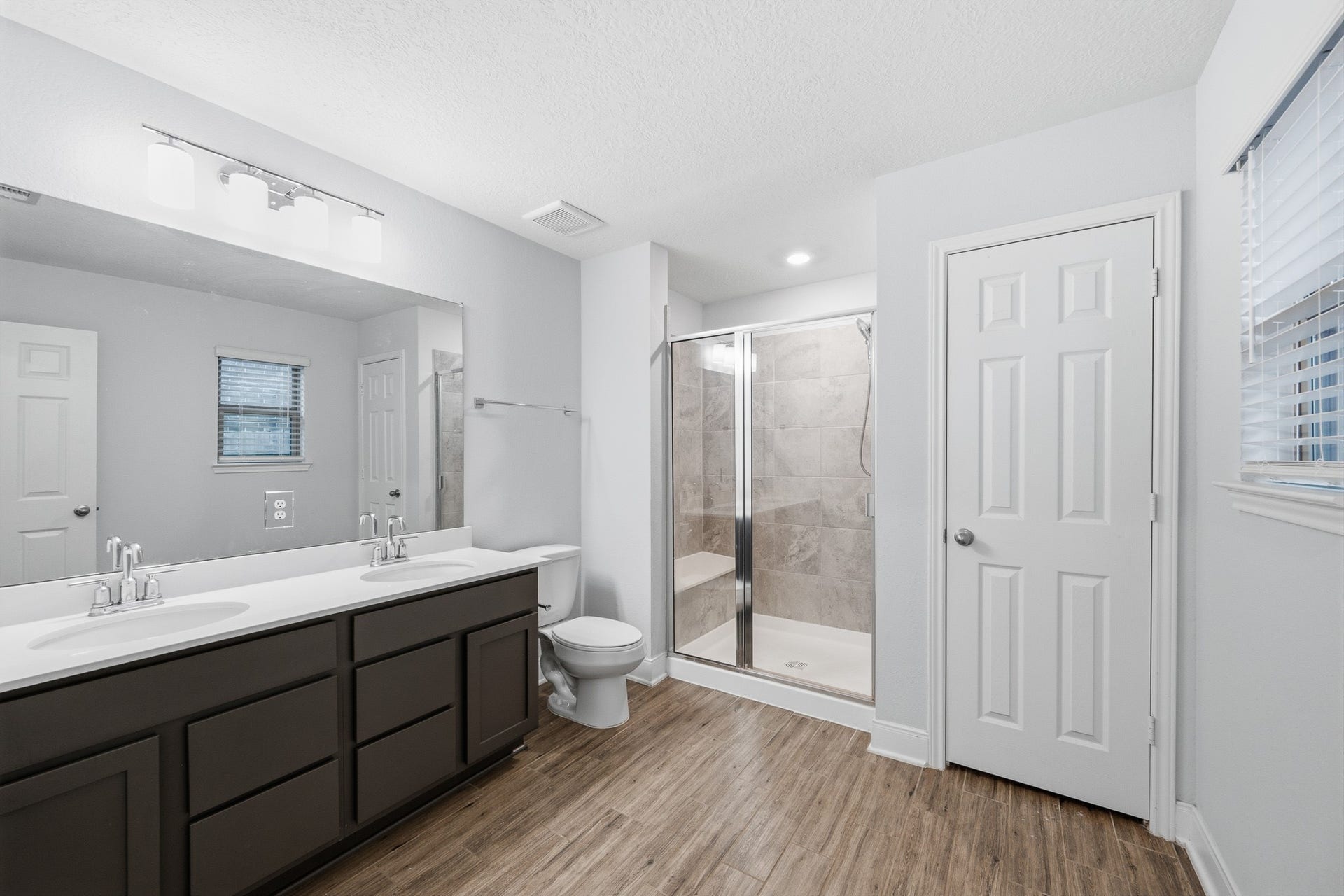 10314 Russell Pines Drive, Rosharon, TX 77583 Spacious bathroom featuring a double vanity with modern fixtures, a glass-enclosed shower, and sleek flooring for a contemporary feel.