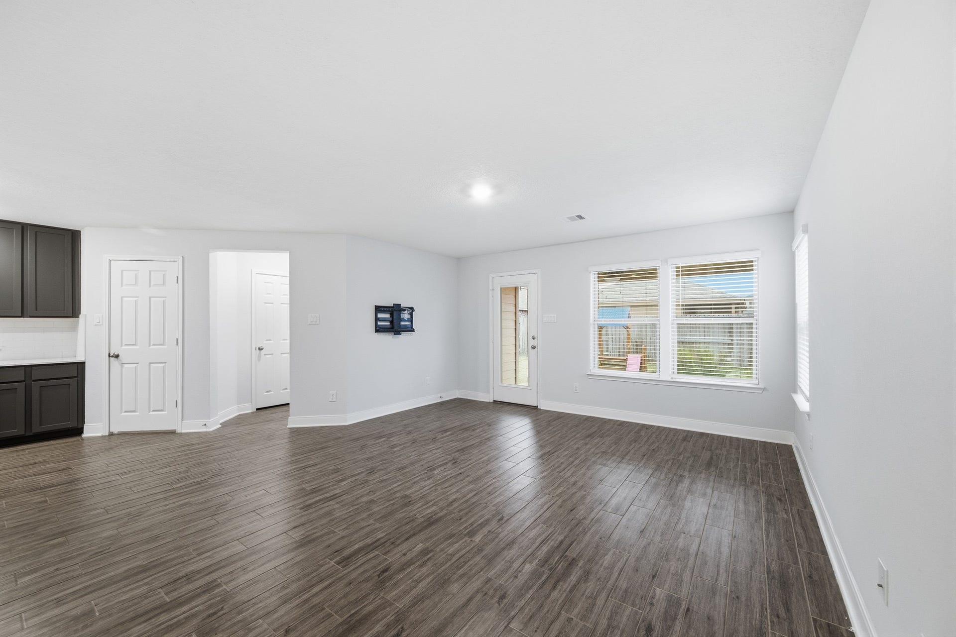 10314 Russell Pines Drive, Rosharon, TX 77583 Spacious living area with sleek flooring, abundant natural light from large windows, and seamless access to the outdoor space through a glass door.