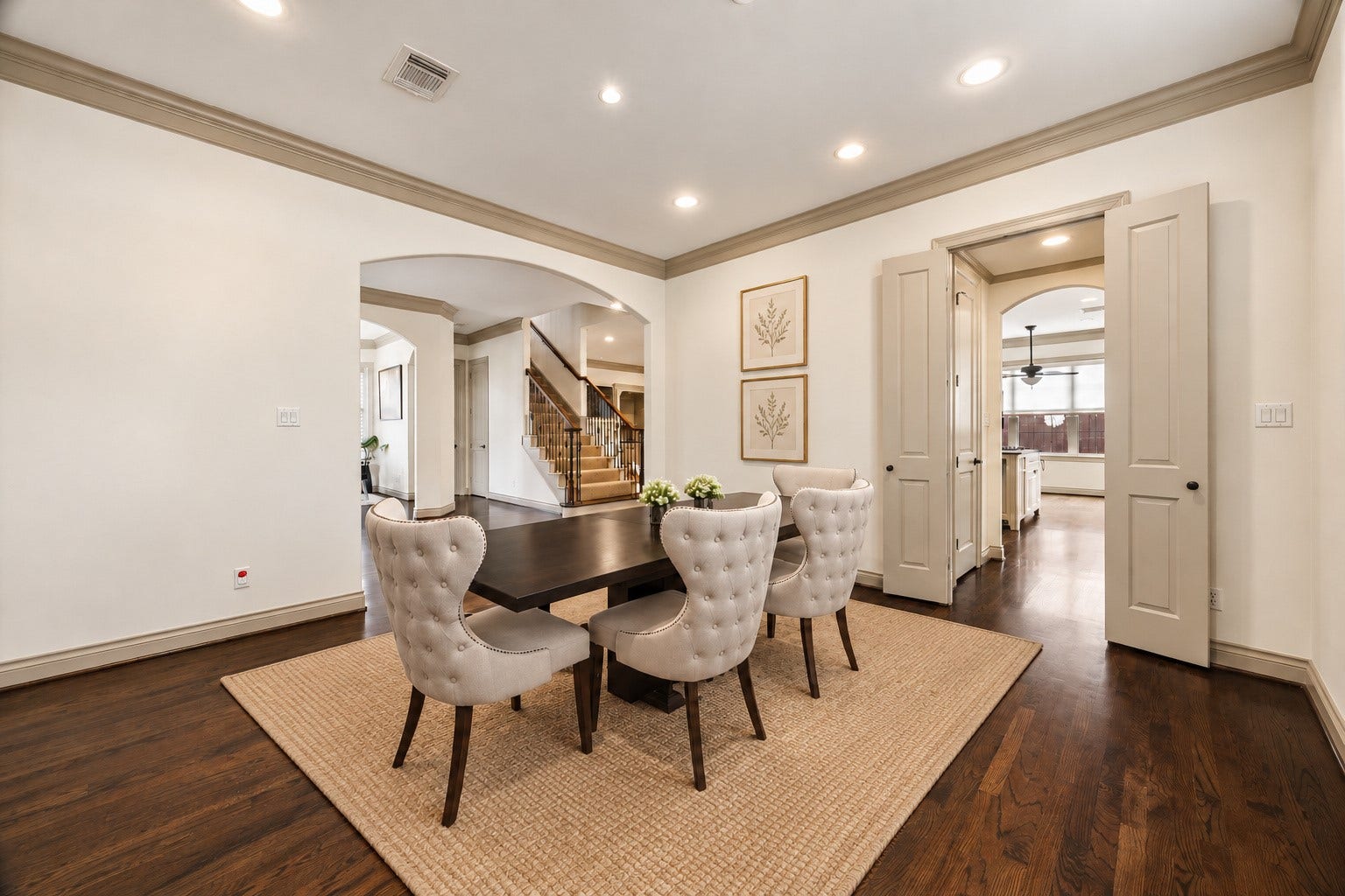 1311 N Jordan Cove, Houston, TX 77055 Another view of the spacious formal dining room showcasing beautiful hardwood floors, crown molding & abundant wall space for artwork or additional furnishings. French doors to the right lead directly to the butler's pantry & kitchen, providing convenient access for serving & entertaining. Wonderful layout for both intimate dinners & larger gatherings! Virtually staged.
