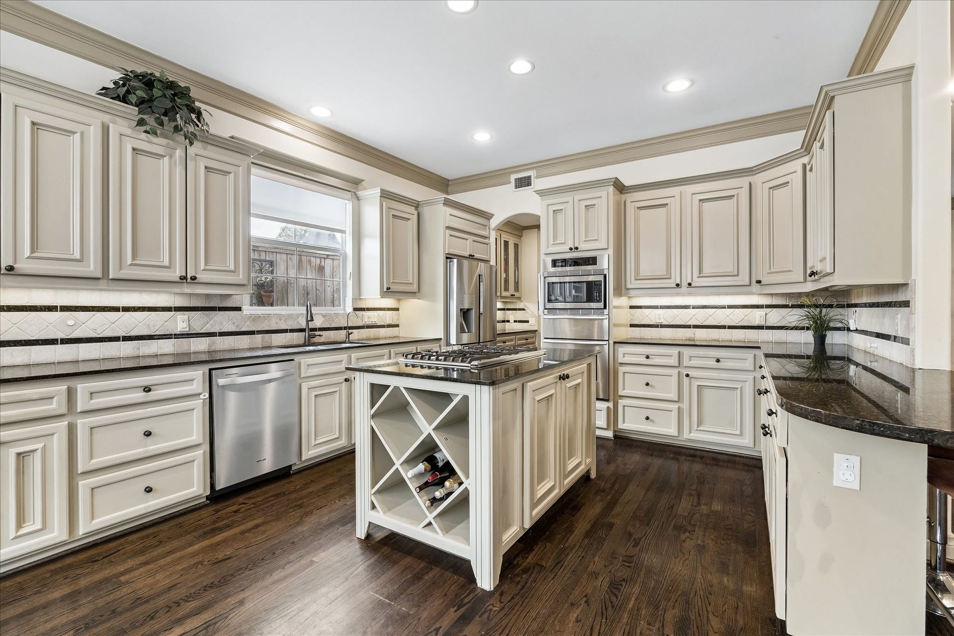 1311 N Jordan Cove, Houston, TX 77055 Fabulous kitchen centered around the island, which features a stainless steel LG 5-burner gas cooktop, cabinetry & wine storage below. Granite countertops, abundant cabinetry & under-cabinet lighting create a beautiful & highly functional heart of the home.