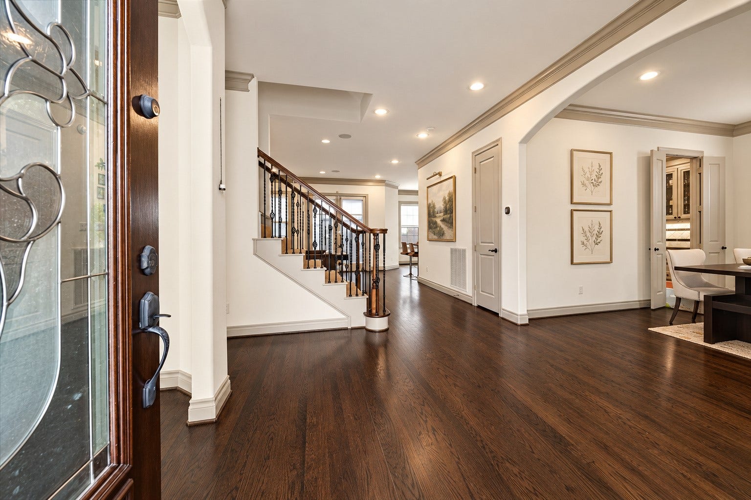 1311 N Jordan Cove, Houston, TX 77055 Upon entering, you are greeted by beautiful hardwood flooring, crown molding, recessed lighting & welcoming entry w/ decorative glass front door. Arched walkways lead to formal living on the let & dining space on the right, while entry hall continues toward family room & kitchen. Notice the generous wall space, offering the perfect place for a console table & artwork. Wall art virtually staged.