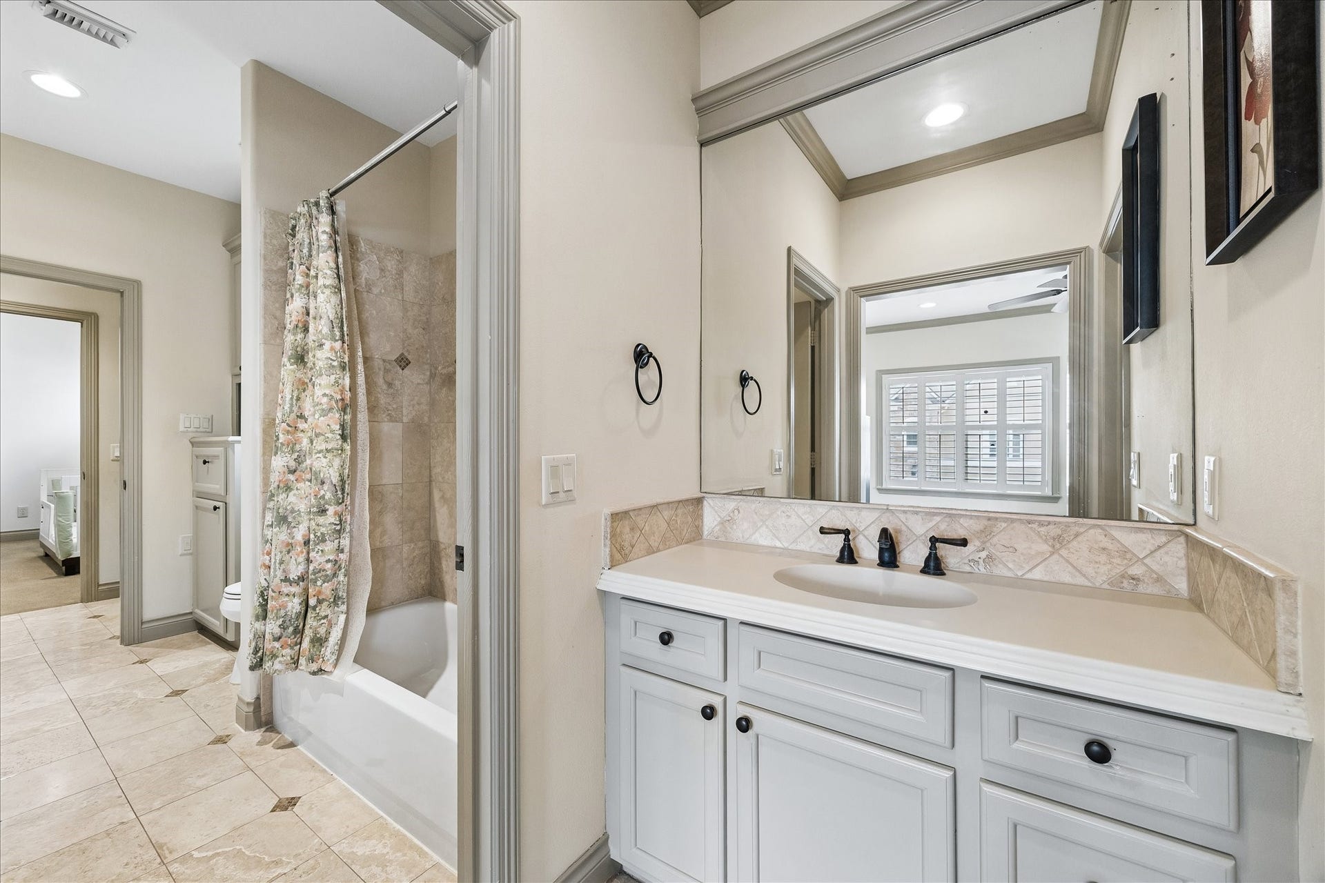1311 N Jordan Cove, Houston, TX 77055 Thoughtfully designed Jack & Jill bath connecting the two 2nd floor secondary bedrooms. Each bedroom features its own private vanity area & separate walk-in closet w/ built-in hanging & shelving, providing excellent storage & privacy. The shared bathing area is conveniently positioned between the two bedrooms w/ a tub/shower combo.