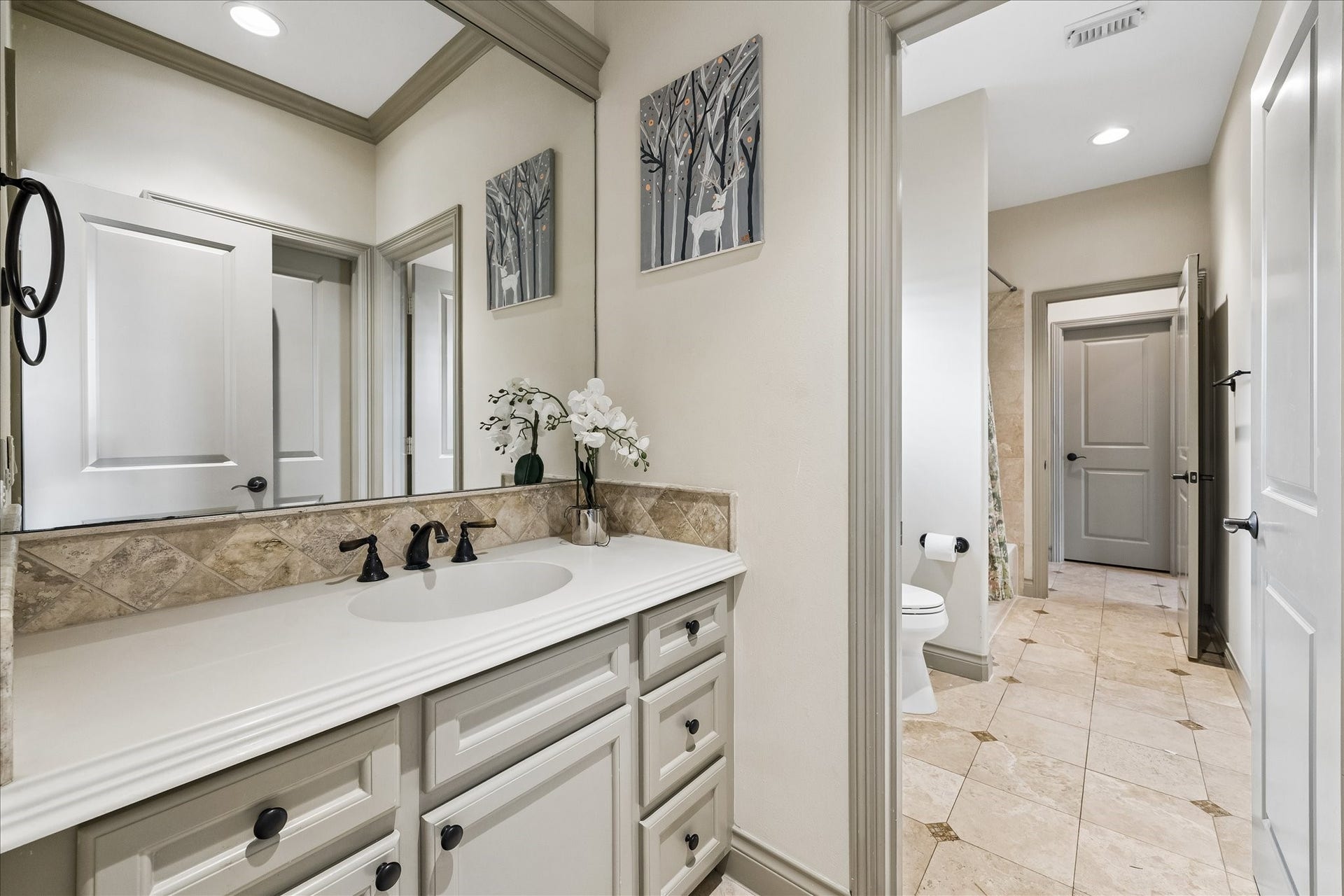 1311 N Jordan Cove, Houston, TX 77055 Another view of the Jack & Jill bath highlighting the one of the two private vanity spaces that caters to each secondary bedroom (w/ a shared bathing area w/ tub/shower combination & toilet). This functional layout allows both secondary bedrooms to enjoy their own private vanity spaces while sharing the separate bathing area, ideal for family or guests.