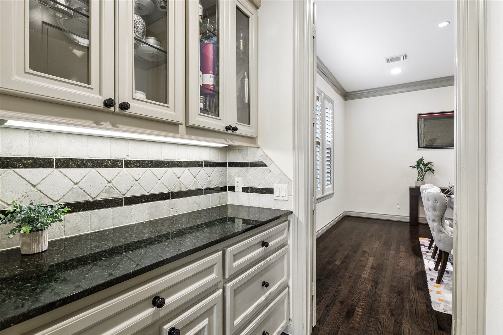 1311 N Jordan Cove, Houston, TX 77055 Dedicated dry bar/butler's pantry thoughtfully positioned between kitchen & formal dining room offers additional storage & serving space. Granite countertops, cabinetry & drawers below, and glass-front display cabinets above provide the perfect place for serving pieces & glassware. A wonderful feature for entertaining! Door to right leads to walk-in pantry.