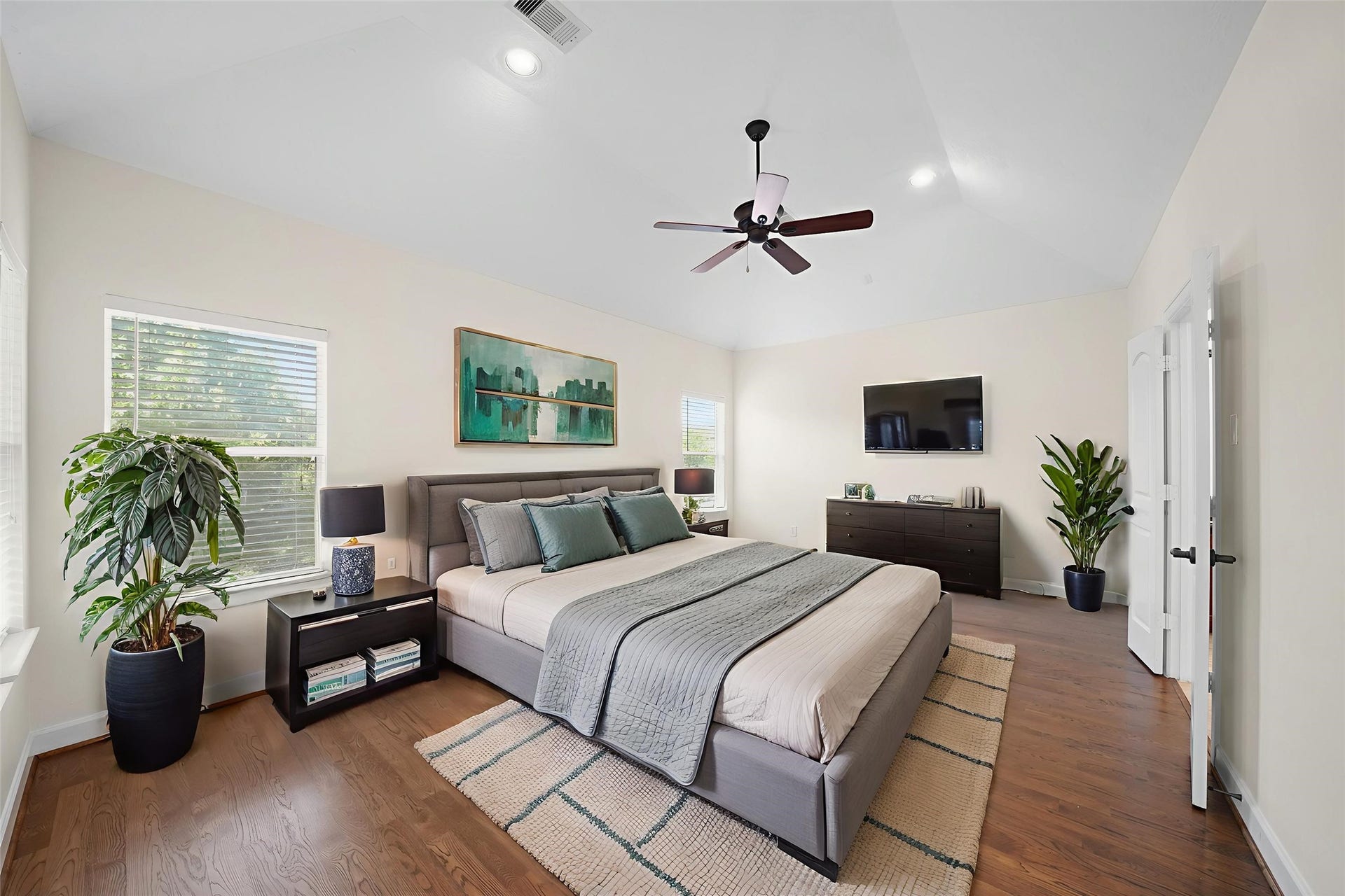 1717 Francis Street, Houston, TX 77004 Virtually Staged: The primary bedroom includes hardwood floors, a high vaulted ceiling, recessed lighting, and windows with privacy blinds.