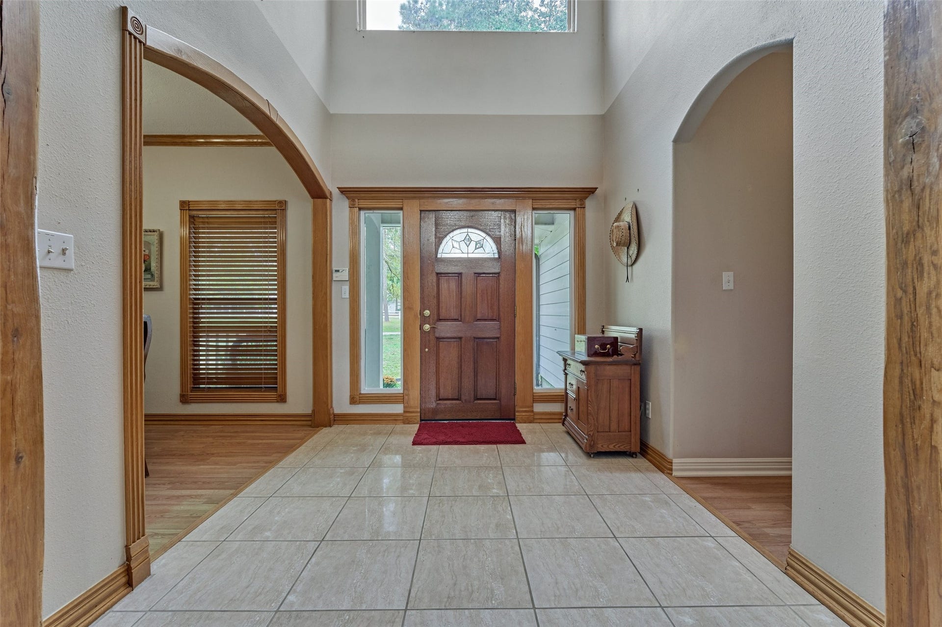 28911 Sapphire Circle, Magnolia, TX 77355 Inviting foyer with high ceilings, a rich wooden front door, and ample natural light, complemented by tile flooring and arched entryways.