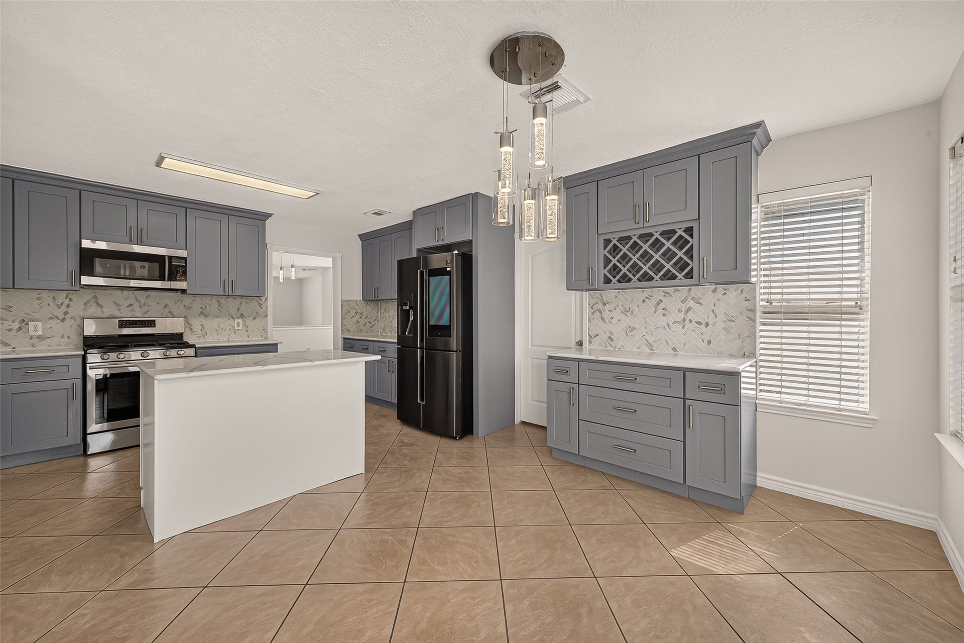 3111 Lantern Bay Lane, Katy, TX 77449 Another angle from the breakfast room of the kitchen, that showcases the dedicated beverage station with a built-in wine rack, pendant lighting over the island, and plenty of cabinetry for storage.