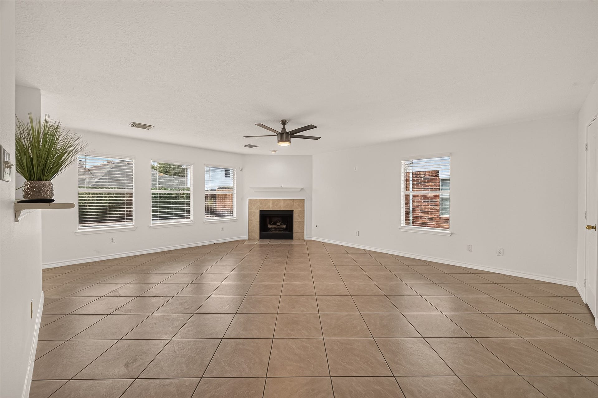 3111 Lantern Bay Lane, Katy, TX 77449 Gather around the fireplace in this spacious family room, where four windows bring in plenty of natural light and tile flooring makes everyday living easy.