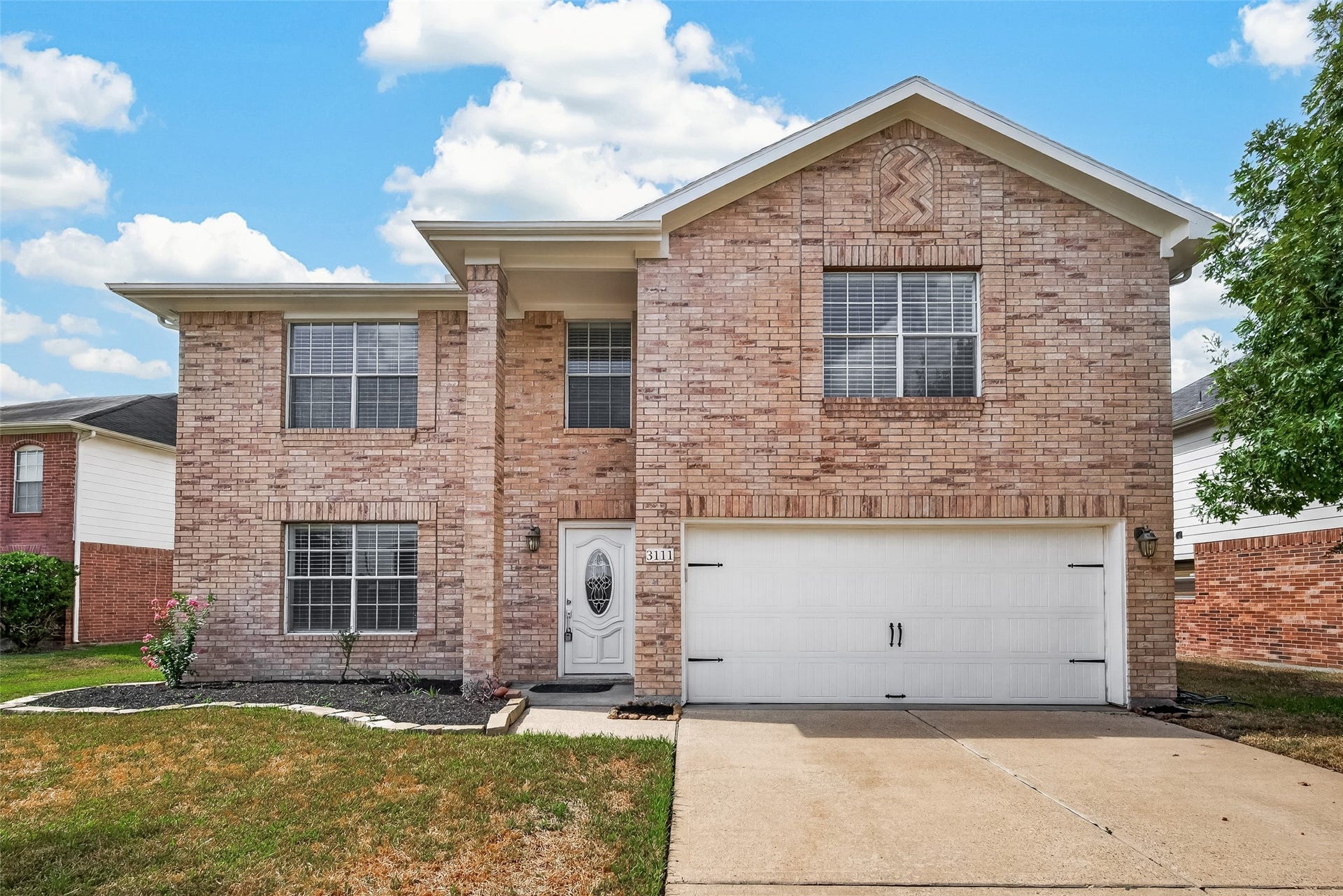 3111 Lantern Bay Lane, Katy, TX 77449 Welcome home to a charming brick exterior with distinctive gable brickwork, a double-wide driveway, and a two-car garage.