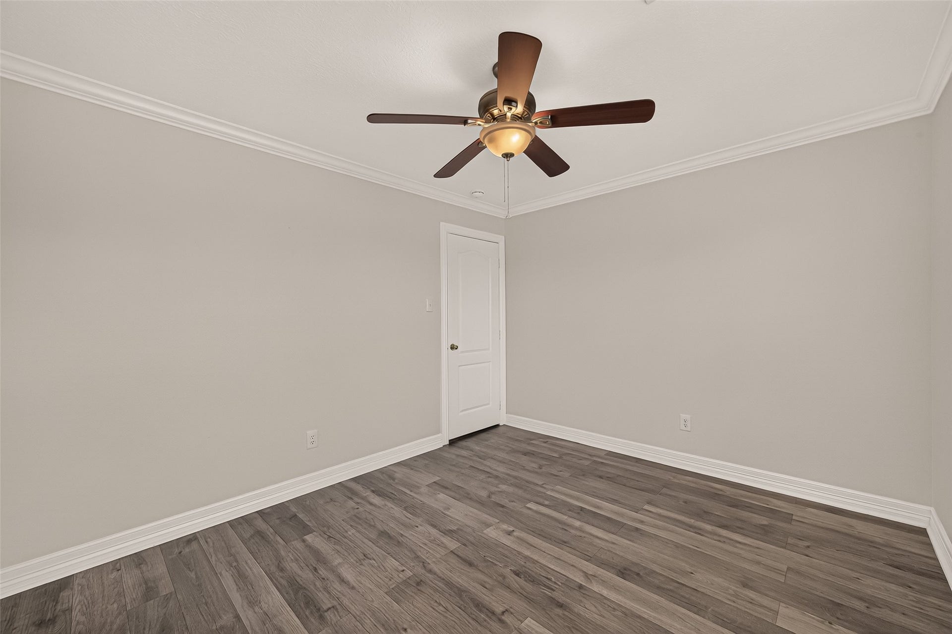 3111 Lantern Bay Lane, Katy, TX 77449 This second guest bedroom pairs vinyl flooring with crown molding and a ceiling fan, offering a clean slate for a cozy retreat or home office.