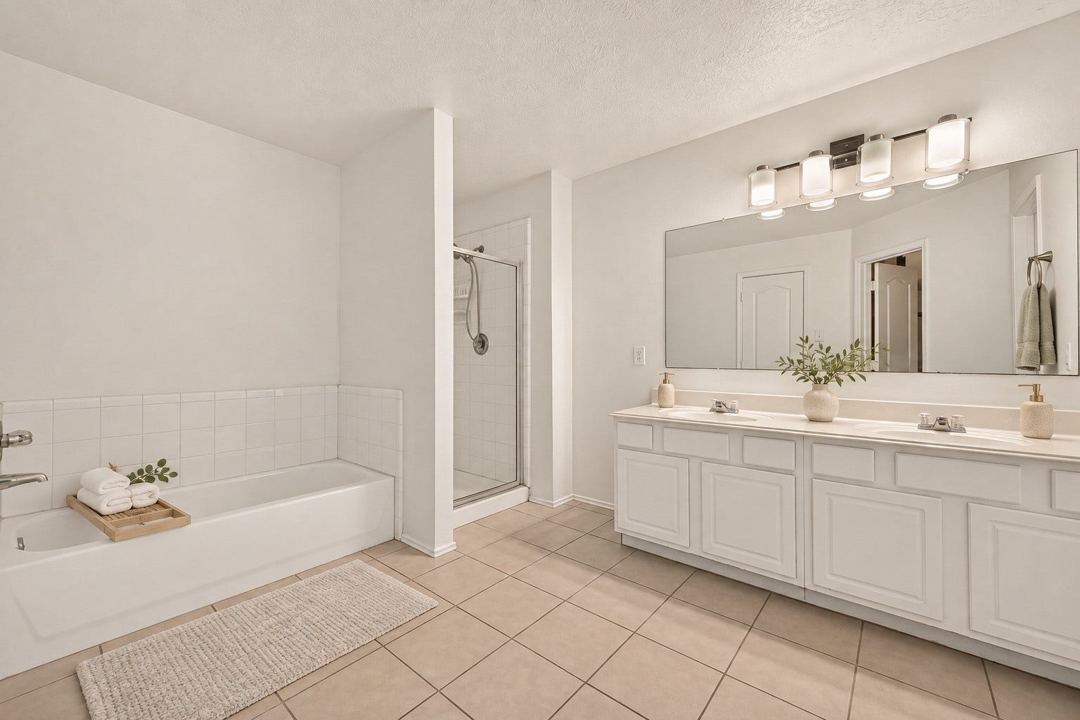 3111 Lantern Bay Lane, Katy, TX 77449 The primary bathroom features a double vanity, soaking tub, and separate glass-enclosed shower. Virtually staged.