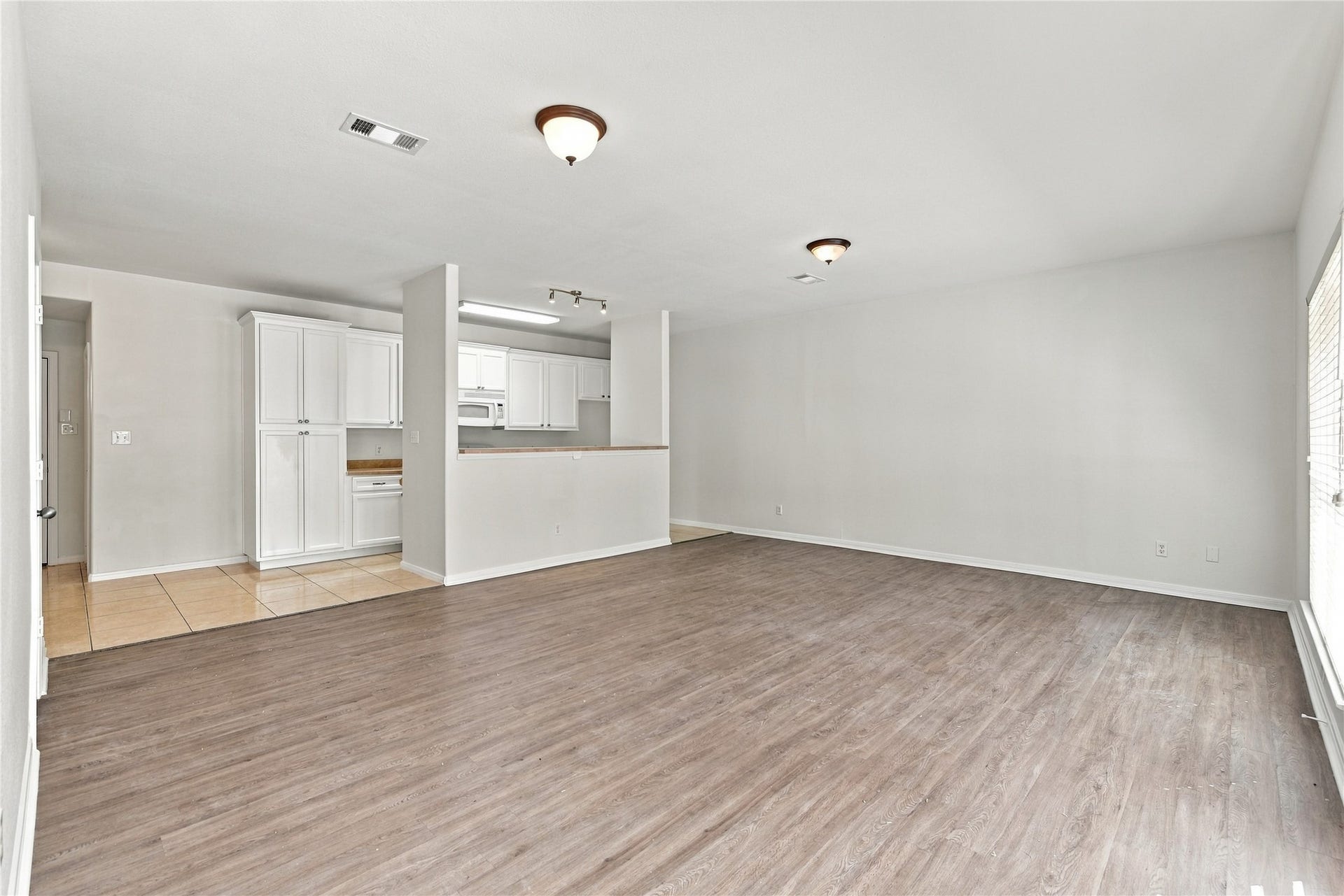 view of family room and kitchen from the bottom of the stairs