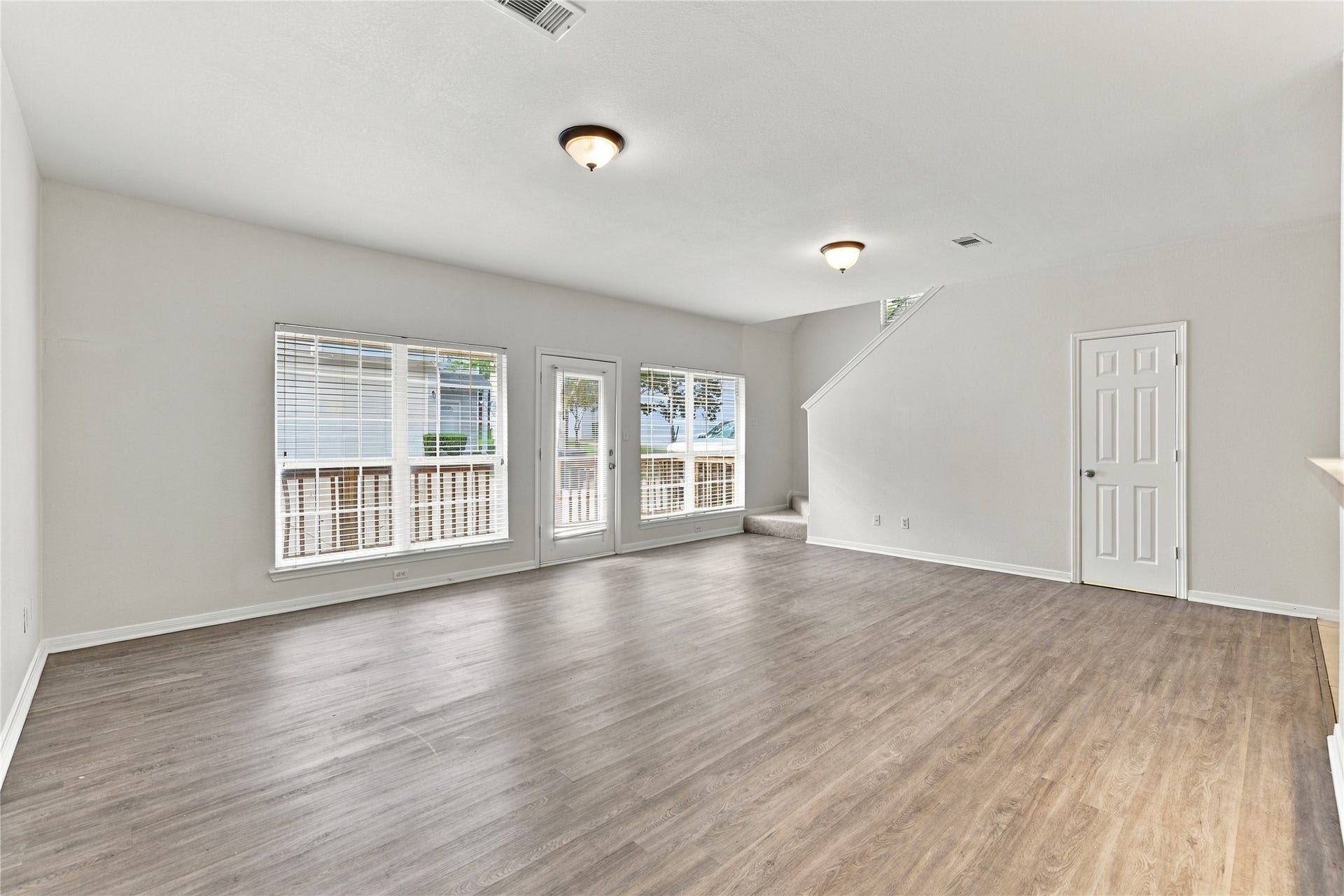 family room, windows and door leading to fenced deck in back of unit, stairs, half bath