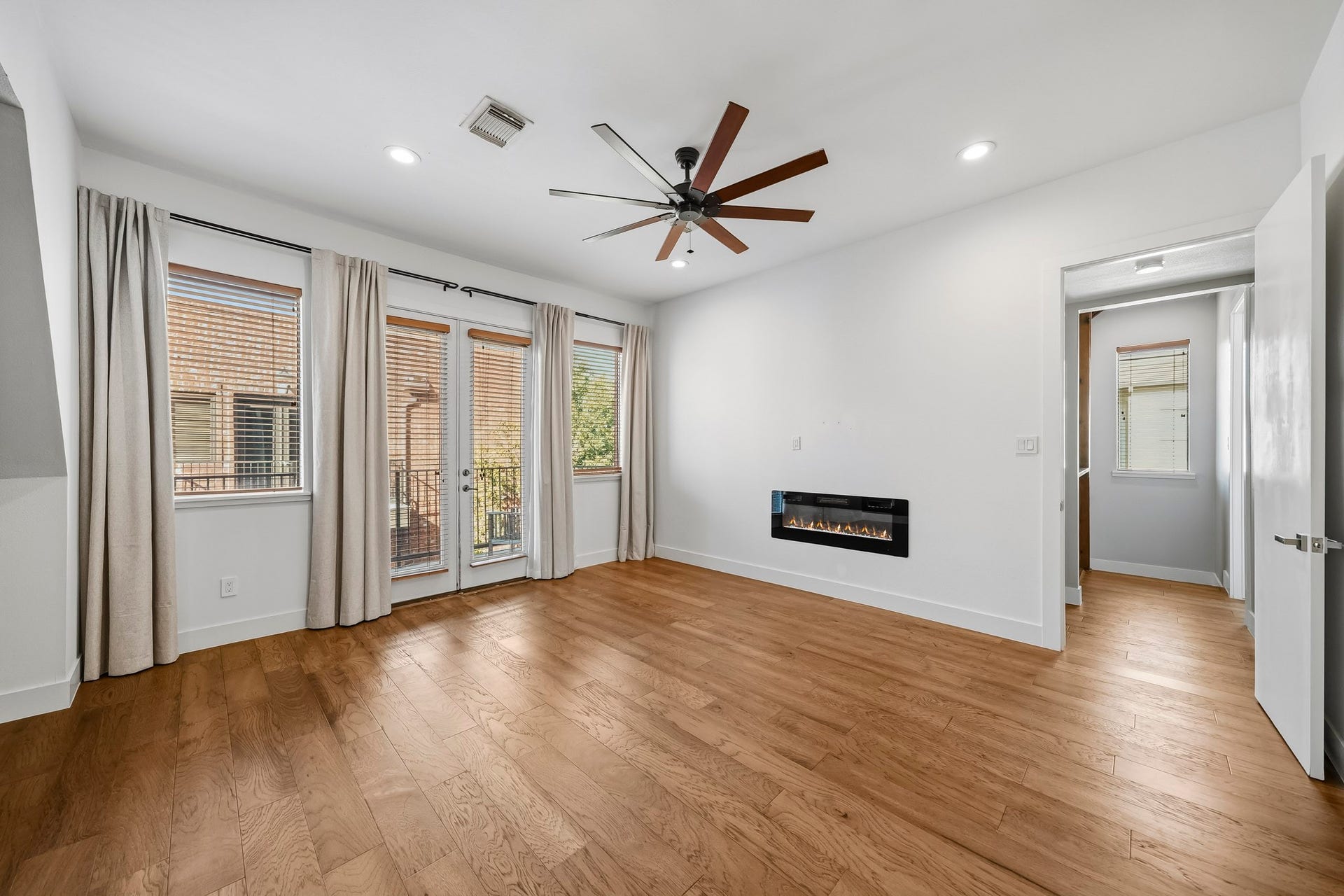 910 Malone Street, #106, Houston, TX 77007 An impressive 8-foot patio door opens from the primary suite to a private balcony, creating a seamless connection to the outdoors. A sleek, linear electric fireplace adds warmth and contemporary elegance, enhancing the suites luxurious ambiance.