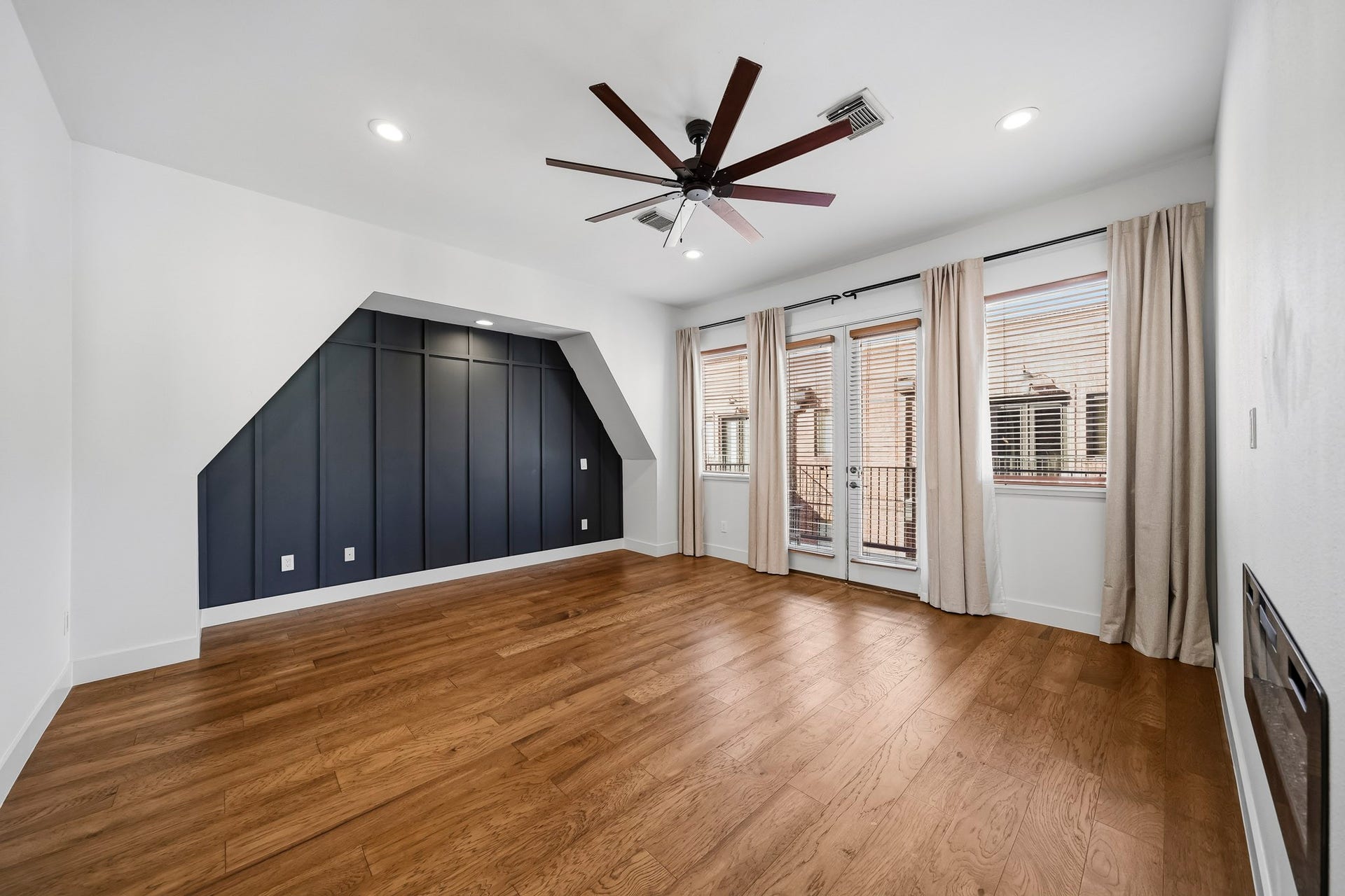 910 Malone Street, #106, Houston, TX 77007 The third-floor primary suite offers a luxurious private retreat, featuring rich hardwood floors, newly installed recessed lighting and a ceiling fan. Elegant picture-frame molding creates a striking accent wall, adding architectural character and sophistication to this beautifully appointed space.