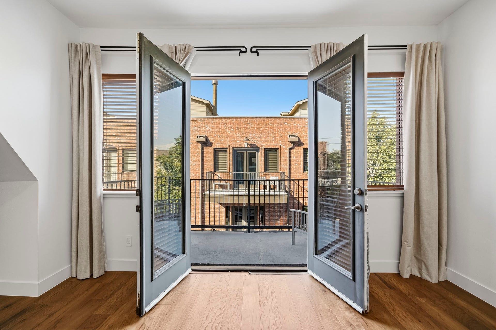 910 Malone Street, #106, Houston, TX 77007 Elegant doors open from the third-floor primary suite to a private balcony, creating a seamless extension of the living space and an inviting outdoor retreat for morning coffee or relaxing at the end of the day.