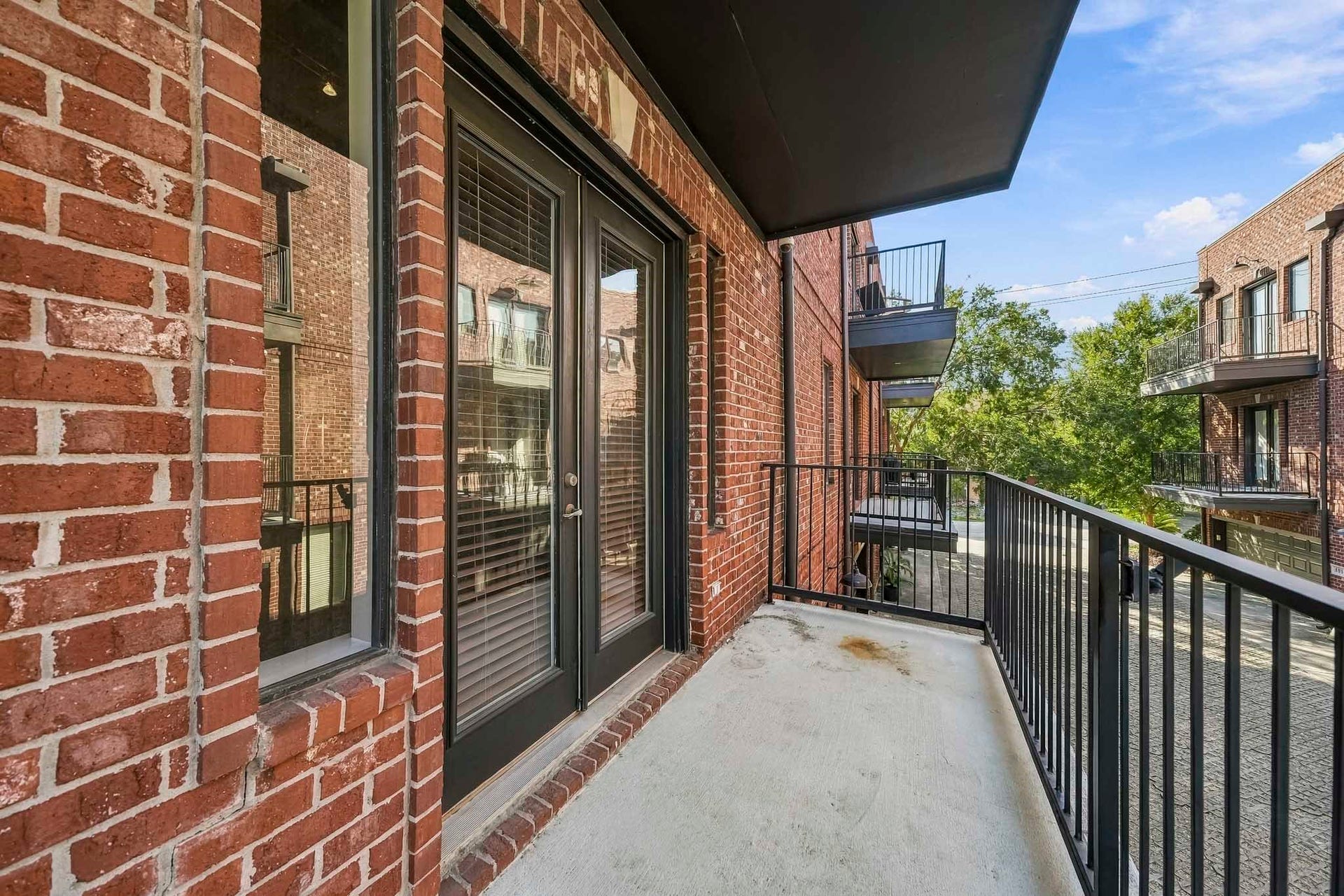910 Malone Street, #106, Houston, TX 77007 Just off the family room, this inviting covered balcony offers a private outdoor retreat and is one of three balconies throughout the home. An ideal setting for morning coffee, alfresco dining, or relaxing in the evening breeze, it extends the living space outdoors with comfort and style.