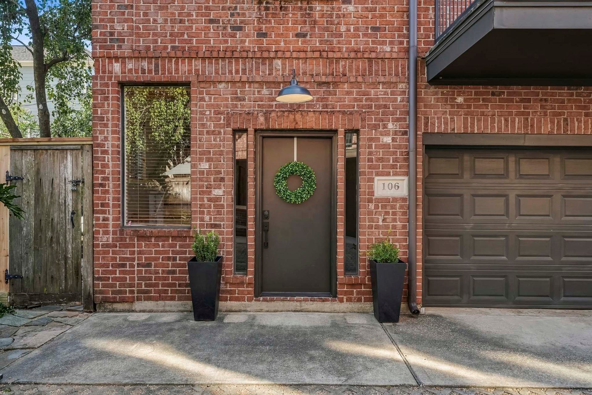 910 Malone Street, #106, Houston, TX 77007 A new front door was installed in 2024 and is flanked by side lights with a two-car garage and an entry on the left to the spacious patio.