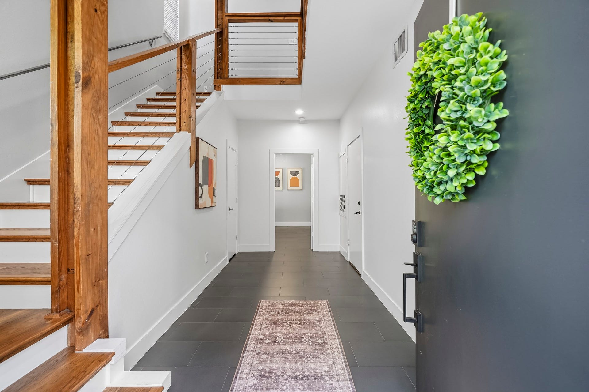 910 Malone Street, #106, Houston, TX 77007 A tiled entry welcomes you into the home with rich wood stair treads and an open staircase extending to the fourth floor create a striking architectural feature, while the soaring ceiling enhances the sense of openness and vertical grandeur throughout the home.