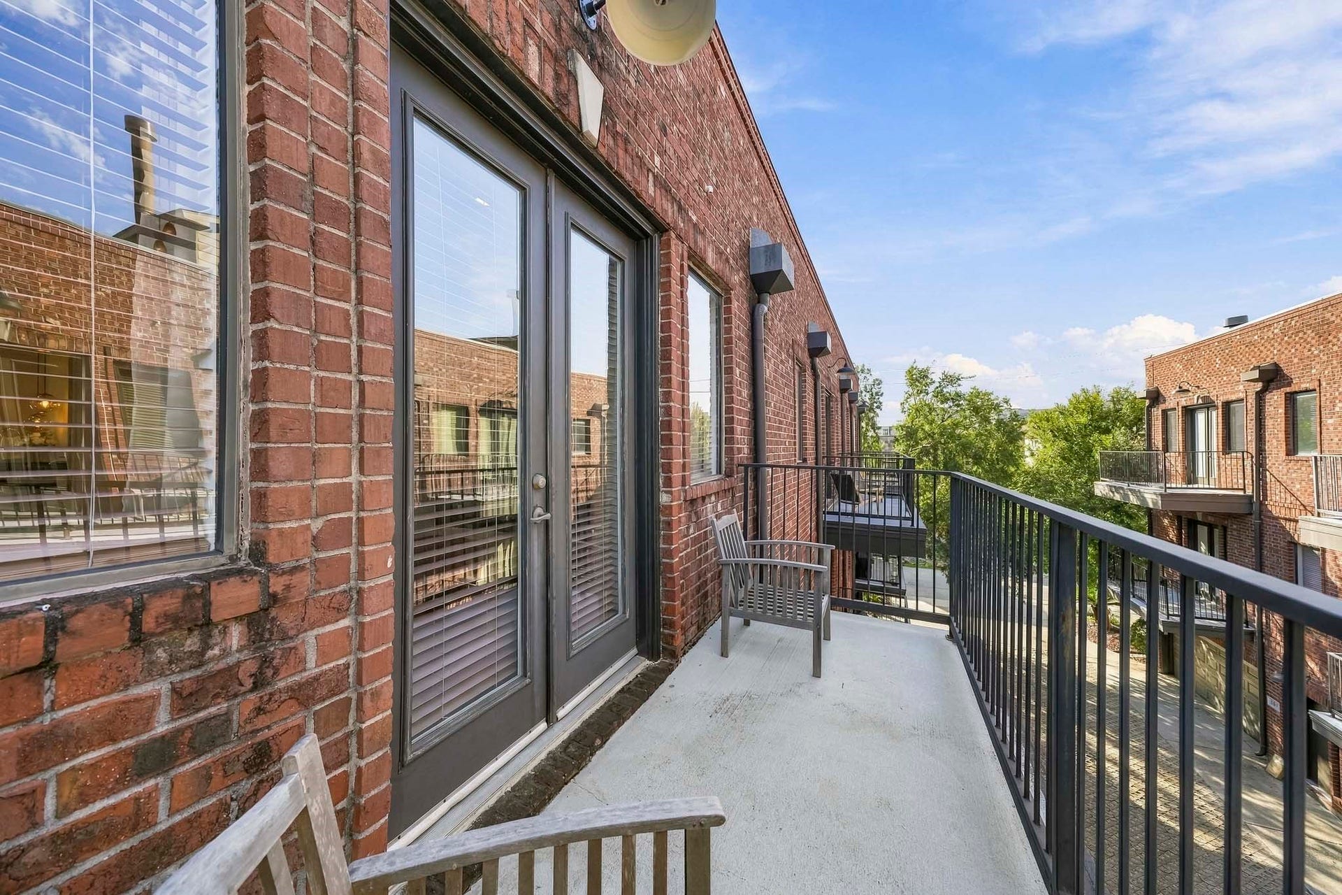 910 Malone Street, #106, Houston, TX 77007 French doors from the primary suite open to a private third-floor balcony, offering an elevated outdoor escape perfect for enjoying morning coffee, taking in the fresh air or relaxing beneath the evening sky.