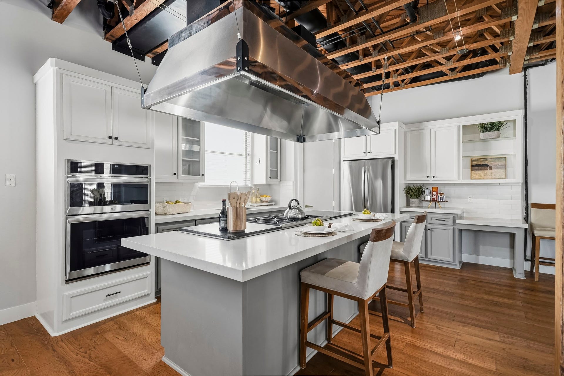 910 Malone Street, #106, Houston, TX 77007 The beautifully appointed kitchen is anchored by an impressive 10-foot island topped with elegant Quartz countertops. A professional-grade six-burner Wolf cooktop and commercial-style ventilation hood creates a chef-inspired setting that combines exceptional culinary performance with sophisticated design.
