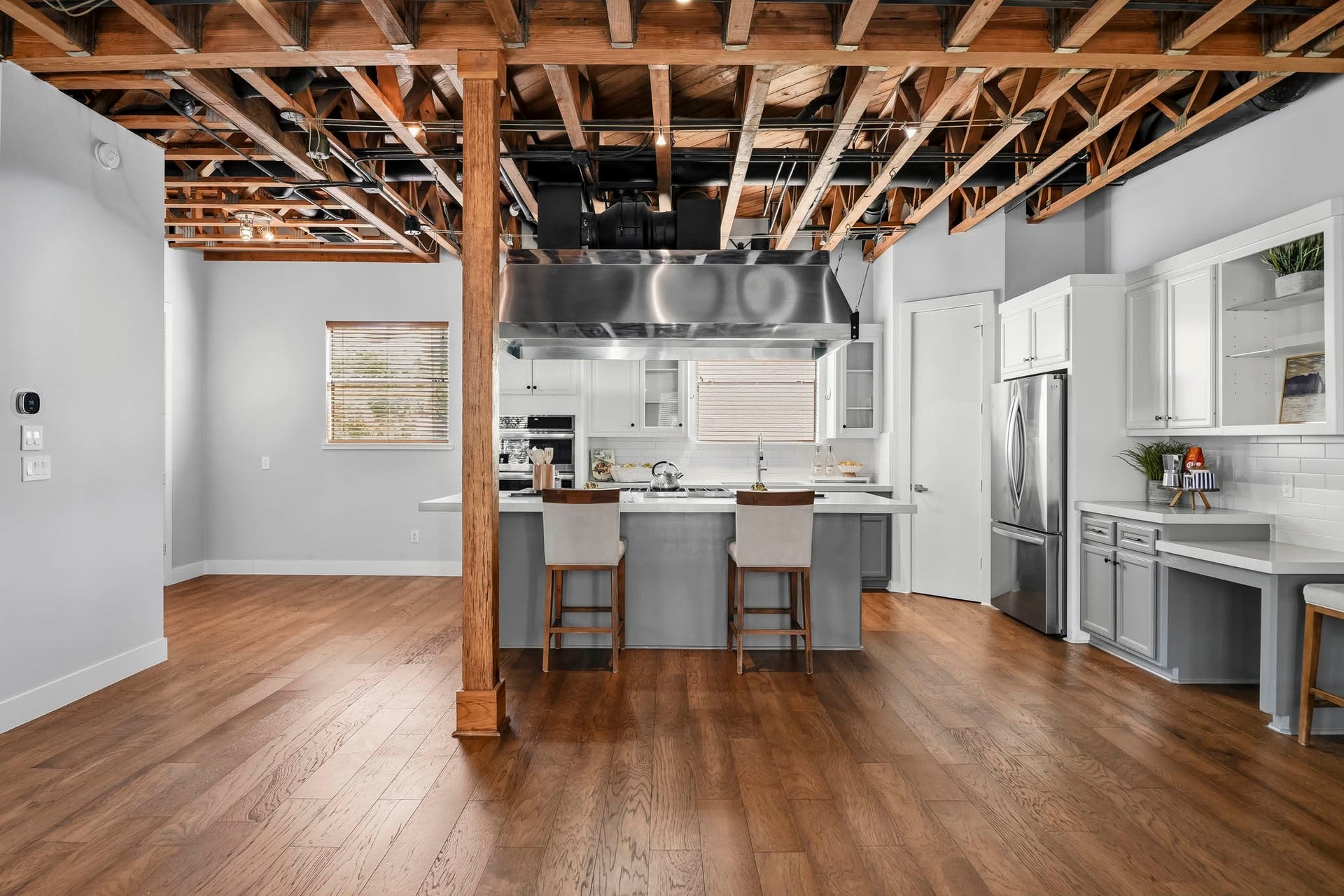 910 Malone Street, #106, Houston, TX 77007 The inviting breakfast bar features rich hardwood floors and windows that welcomes natural light, creating a warm and comfortable setting for casual dining and leisurely mornings.