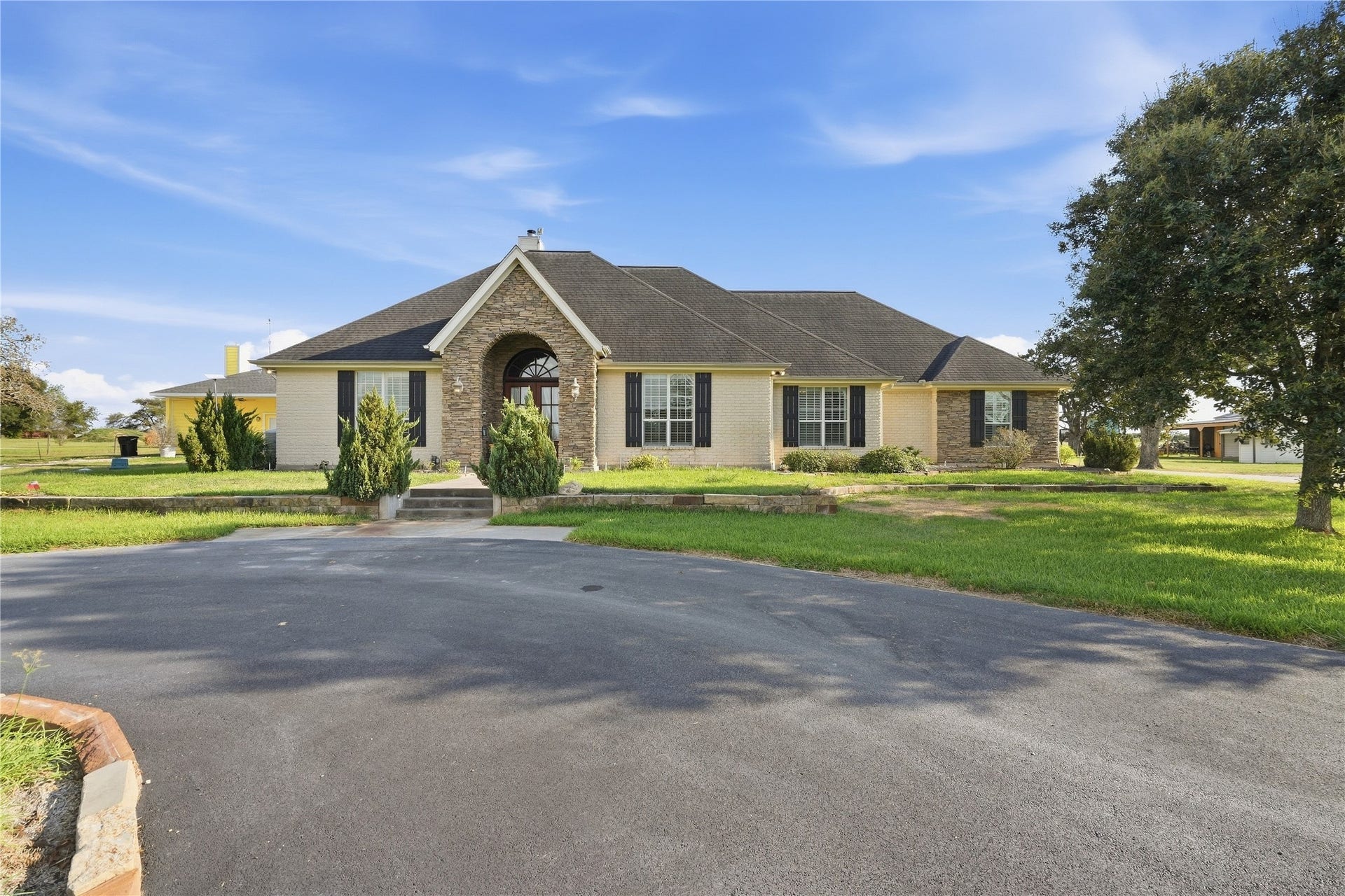 29101 Fm 1736 Road, Hempstead, TX 77445 FRONT OF HOUSE FROM THE CIRCLE DRIVEWAY WITH CUSTOM STONE STEPS LEADING TO THE FRONT PORCH