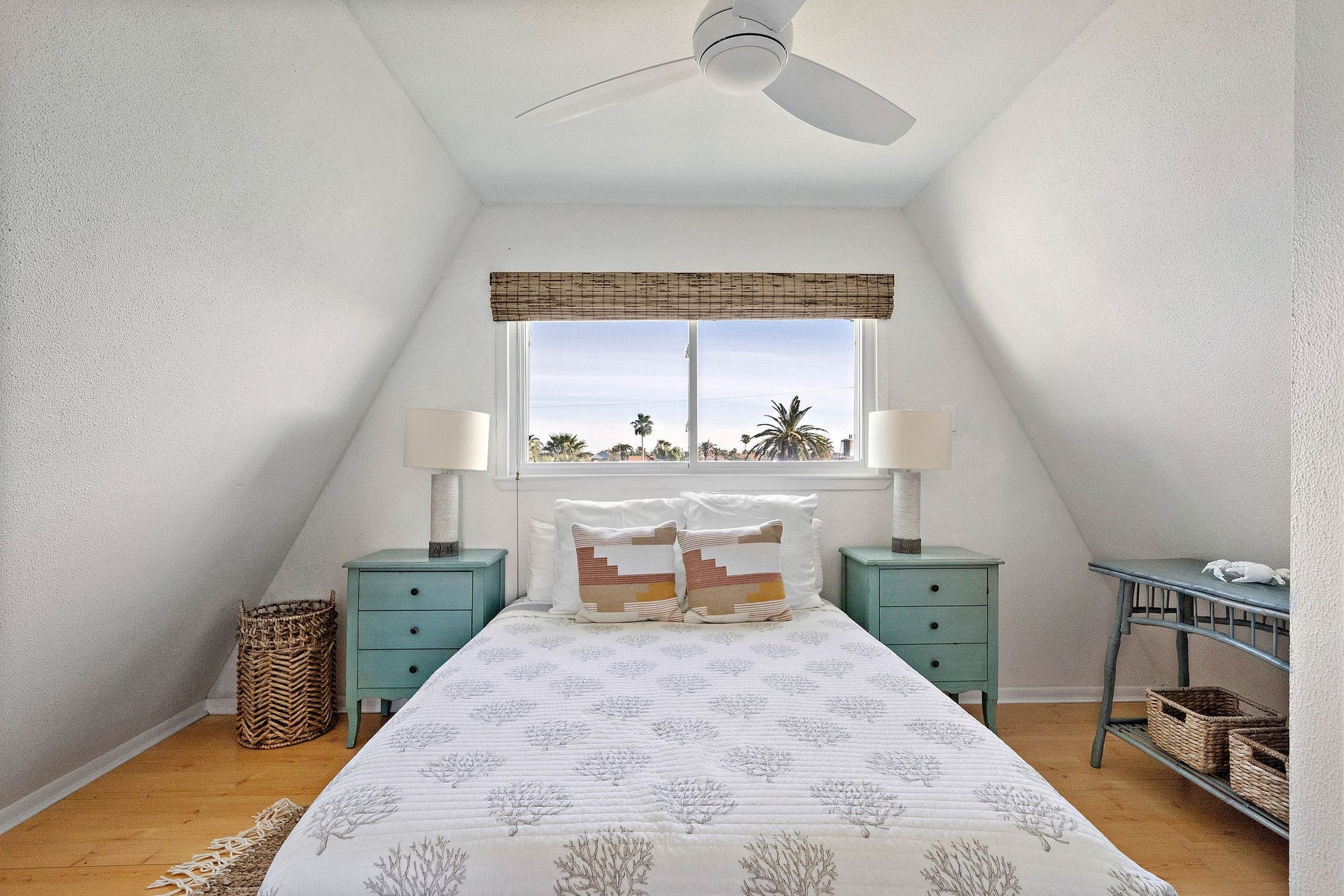 16610 Nassau Way, Galveston, TX 77554 Charming bedroom with a cozy A-frame design, featuring a large window offering scenic views, complemented by soft, natural light and tasteful furnishings.