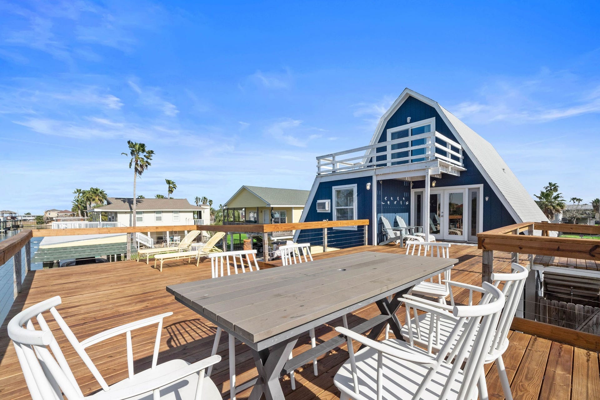16610 Nassau Way, Galveston, TX 77554 Charming A-frame home with a spacious wooden deck, perfect for outdoor dining and relaxation, offering stunning views and a serene atmosphere.