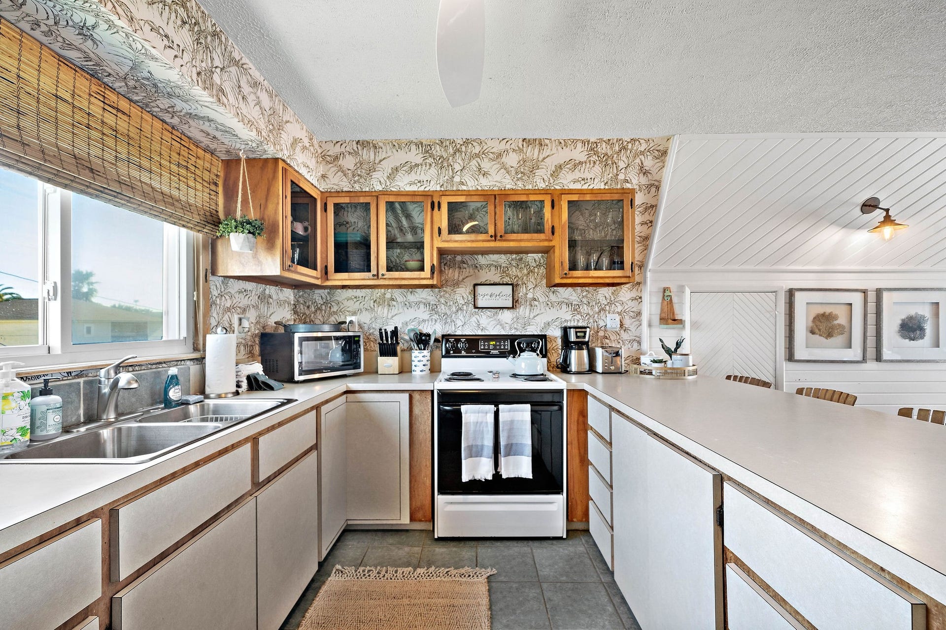 16610 Nassau Way, Galveston, TX 77554 Charming kitchen with vintage wallpaper, wood accents, and ample counter space. Enjoy natural light from well-placed windows and a cozy dining nook.
