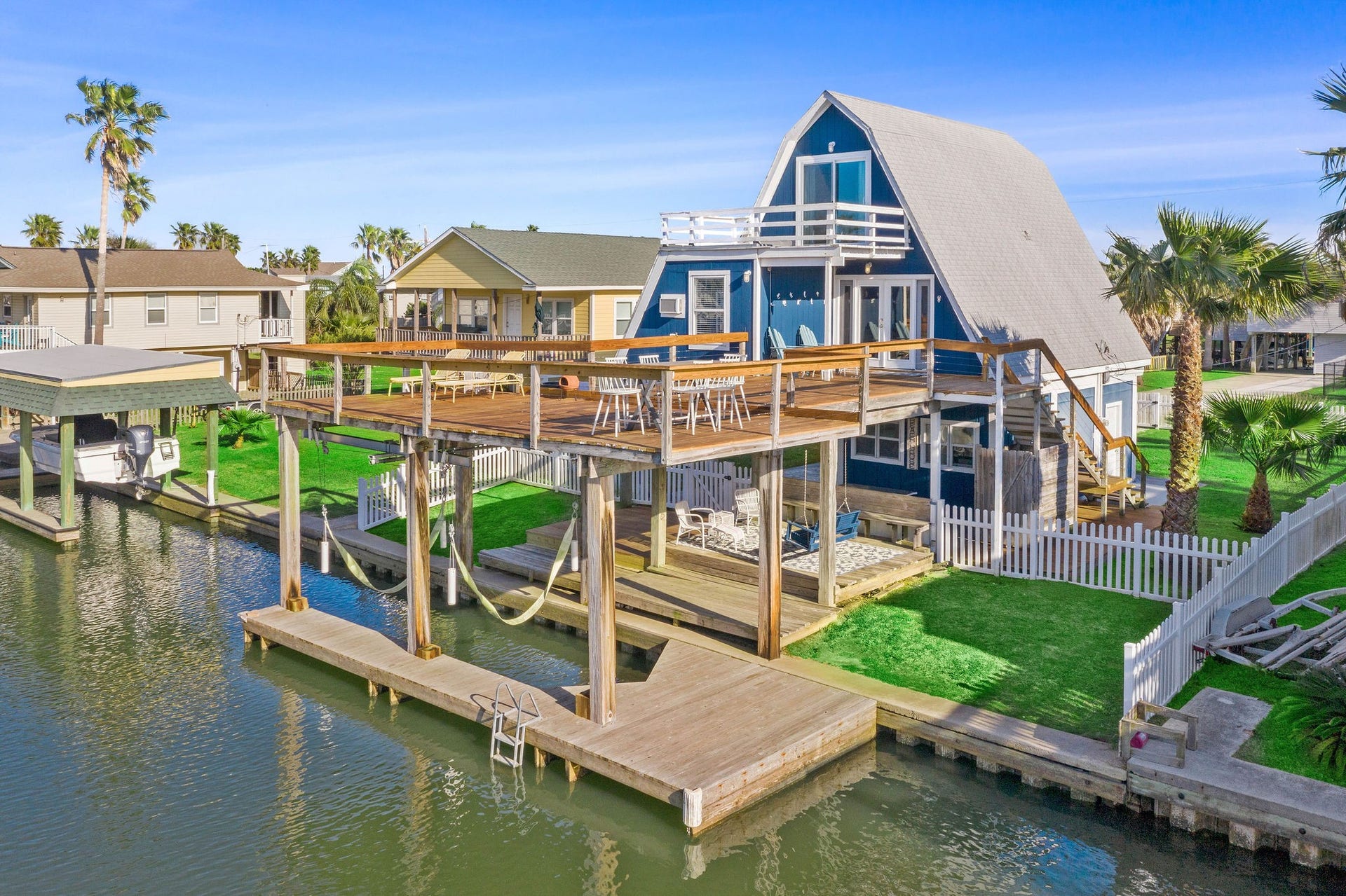 16610 Nassau Way, Galveston, TX 77554 Charming waterfront A-frame home with expansive deck, private dock, and picturesque canal views, perfect for enjoying coastal living.
