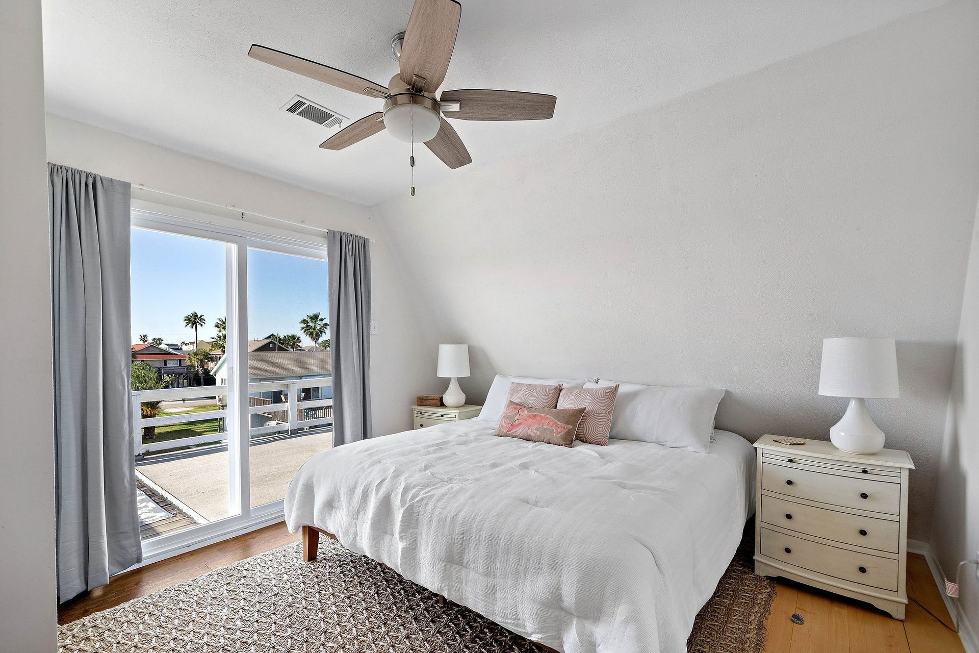 16610 Nassau Way, Galveston, TX 77554 Bright and airy bedroom featuring a large window with scenic views, neutral decor, and a ceiling fan for comfort.