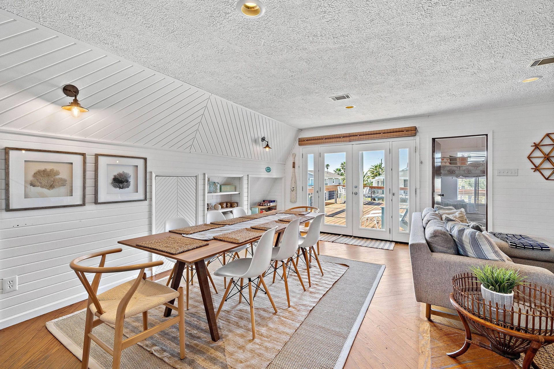 16610 Nassau Way, Galveston, TX 77554 Bright and inviting dining area with stylish wood accents, a large table for gatherings, and French doors leading to a sunlit deck.