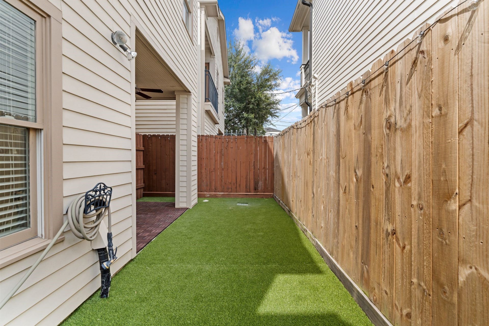 1042 W 25th Street, #B, Houston, TX 77008 Private fenced outdoor space with low-maintenance turf and a covered patio area, perfect for relaxing, pets, or entertaining.