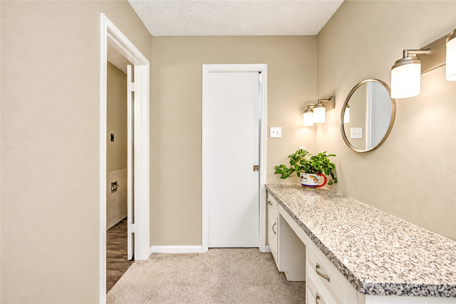 361 Champions Colony III, Houston, TX 77069 Elegant hallway with a sleek granite countertop, modern lighting, and a stylish round mirror, offering a functional and inviting space.