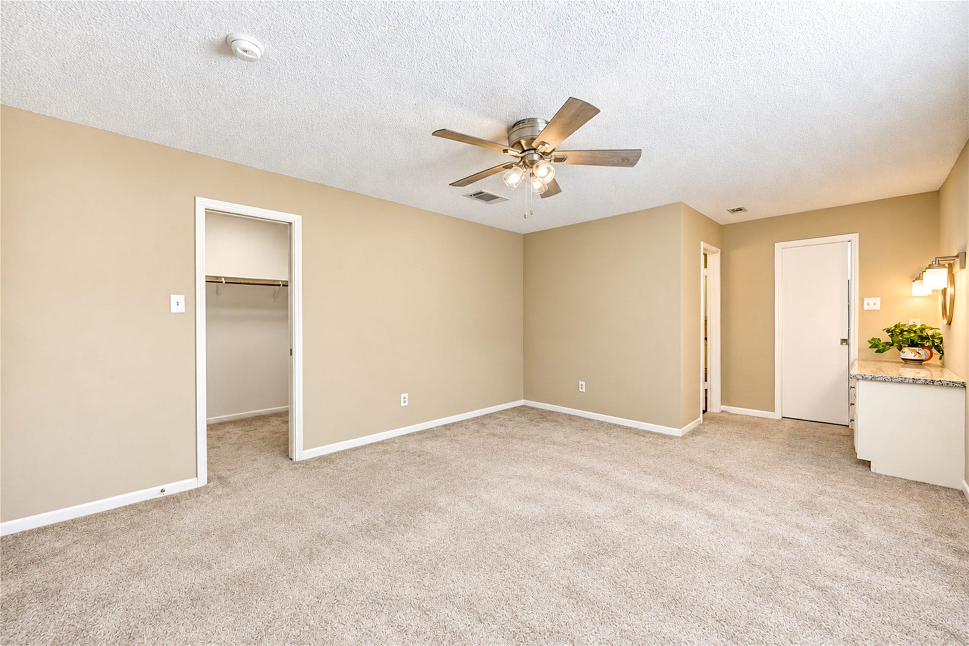 361 Champions Colony III, Houston, TX 77069 Spacious bedroom with neutral tones, featuring plush carpeting, a ceiling fan, and ample closet space for comfortable living.