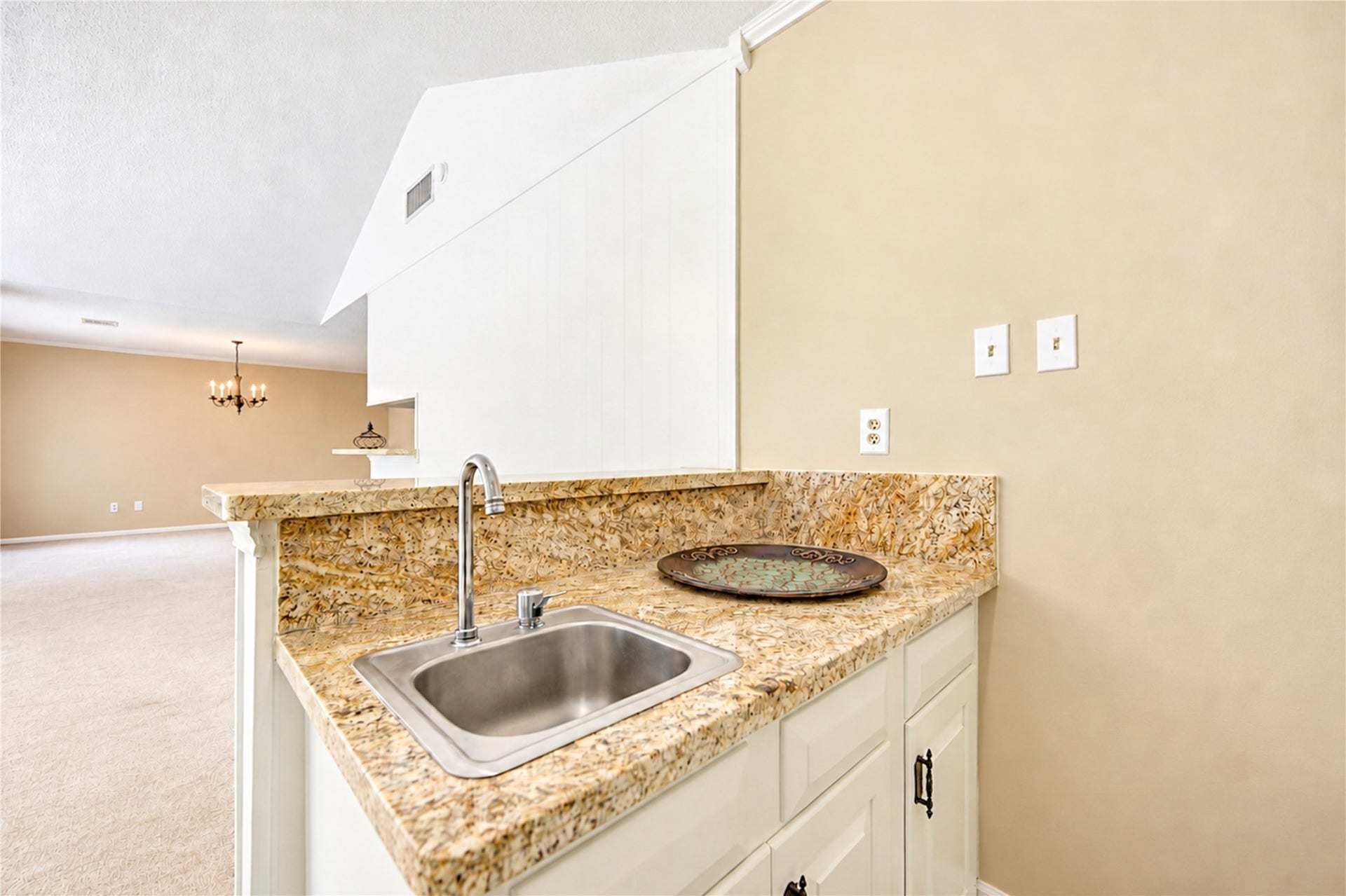 361 Champions Colony III, Houston, TX 77069 Elegant kitchen space with granite countertops and a convenient sink, featuring an open view into a spacious living area with a warm, neutral color palette.